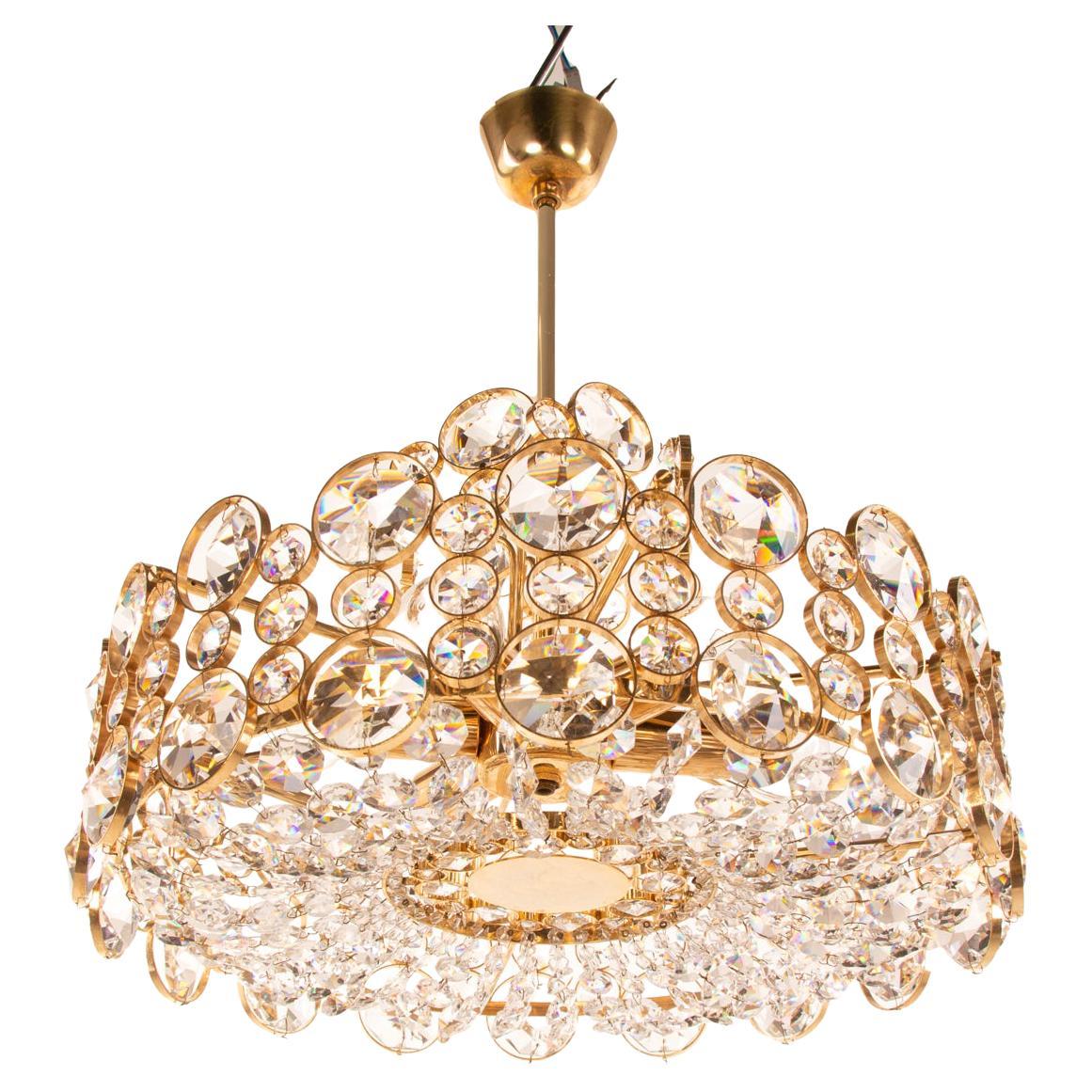 Glamorous bubble chandelier is made of a 24-carat gold-plated brass frame with crystal prisms and gilt brass rings. Manufactured by Palwa (Palme & Walter), Germany in the 1960s. 

Style: Hollywood Regency. 
Colors: clear and golden. 
Materials:
