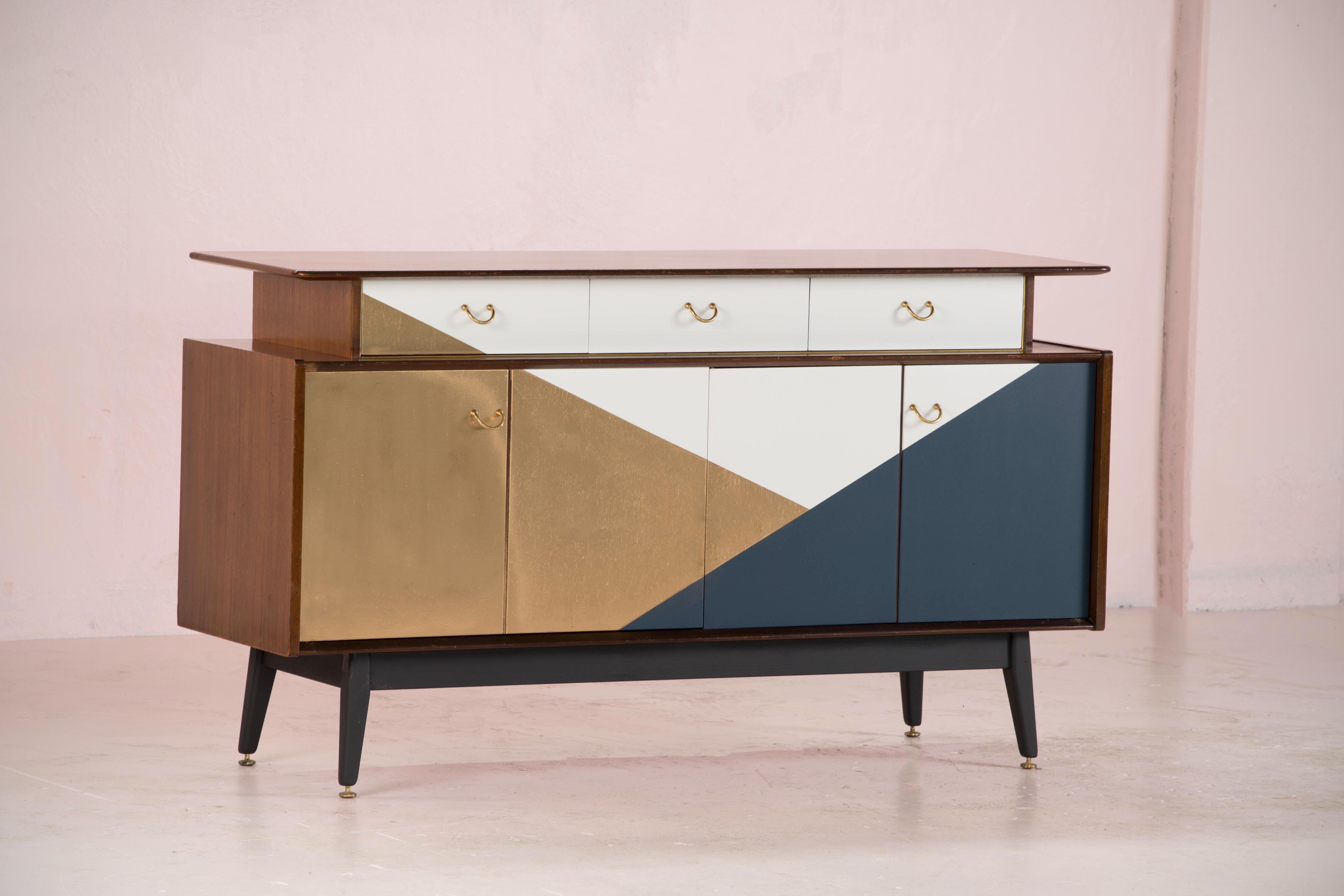 Mid Century sideboard with an handcrafted painted graphic facade.
Golden, navy blue and white.