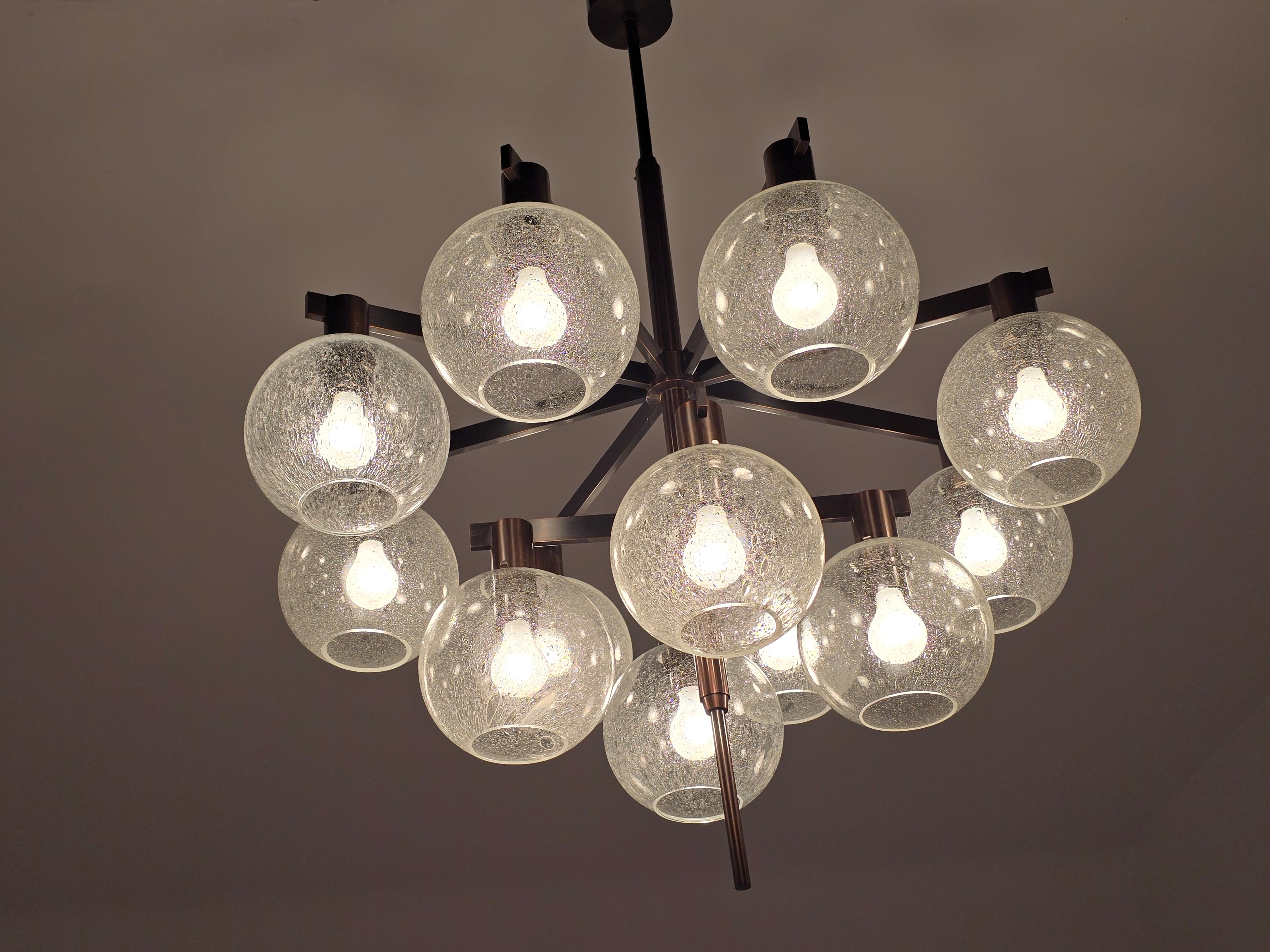 Lampadario Hans-Agne Jakobsson 348/12 con rara finitura in ottone antico.  

Ogni paralume in vetro testurizzato misura 8 pollici di diametro. 

Contenere 12  Presa E26/ E27 da 60 watt ciascuna. 

L'asta superiore misura 43 pollici. L'altezza del