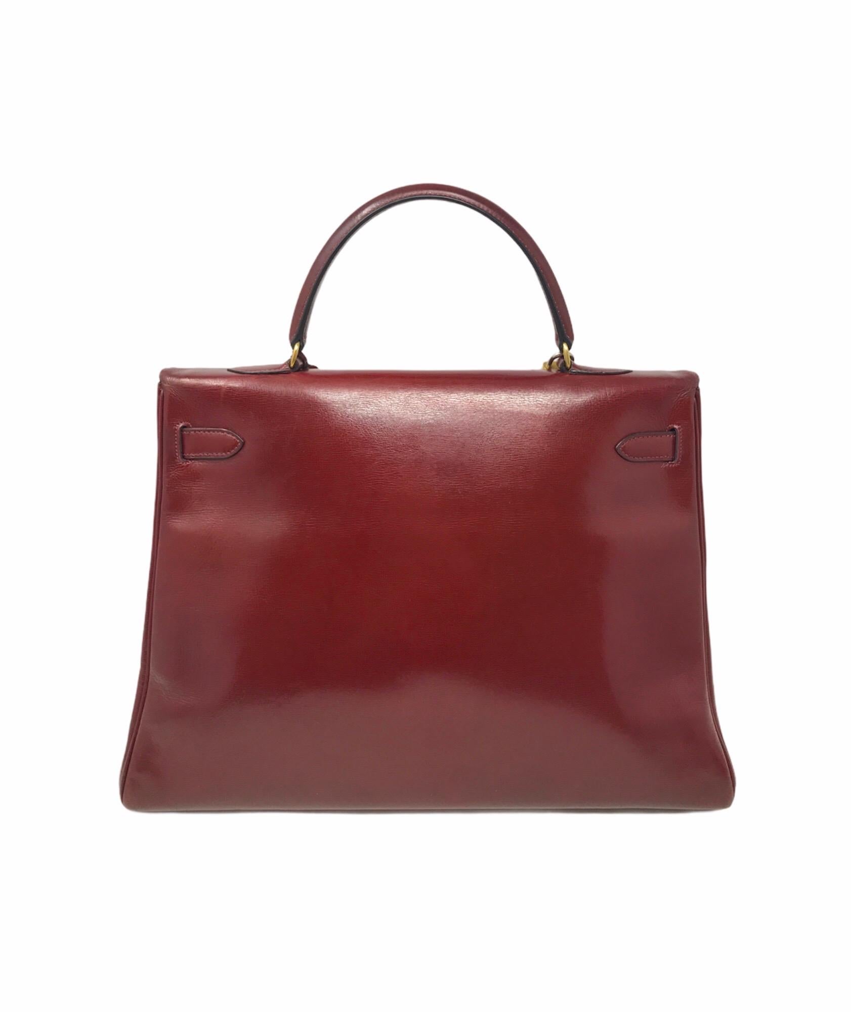 This iconic HERMES Kelly 35 vintage is in bordeaux box leather. The hardware is gold plated.  Included : a clochette, keys and padlock.  This bag is marked by the stamp S, meaning of the year 1960.  It is in good condition. The leather is cracked on