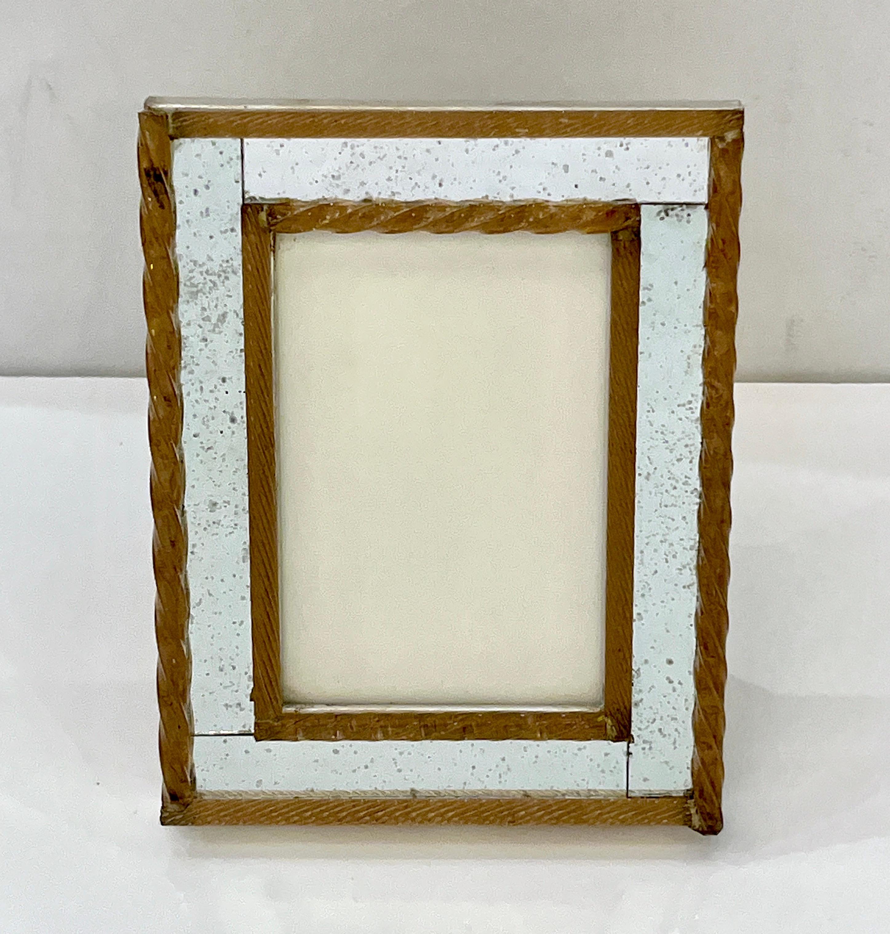 A 1960s elegant Italian vintage minimalist picture frame to add style and simple sophistication to any room. The vintage speckled mirrored frame is double-edged in relief by twisted amber glass baguettes with two different types of twists. The