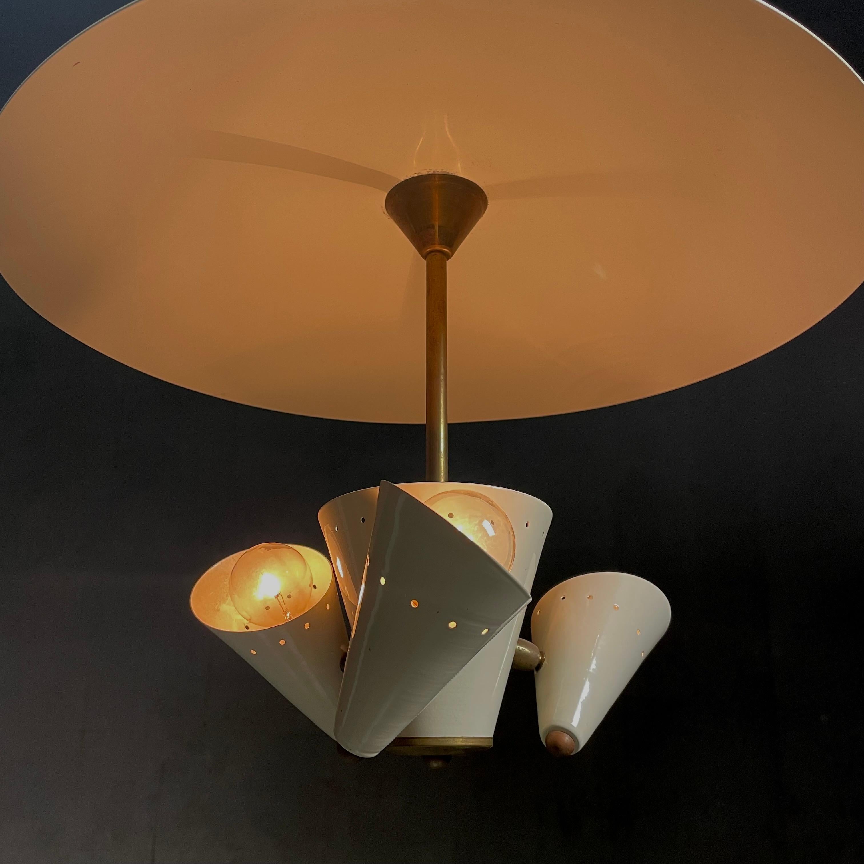 Un'autentica lampada a sospensione a riflettore italiana, con teste girevoli, finitura di fabbrica con dettagli in ottone.  Completamente funzionante secondo gli standard nordamericani. 

Questa lampada ha lo stile Arredolucce, probabilmente di