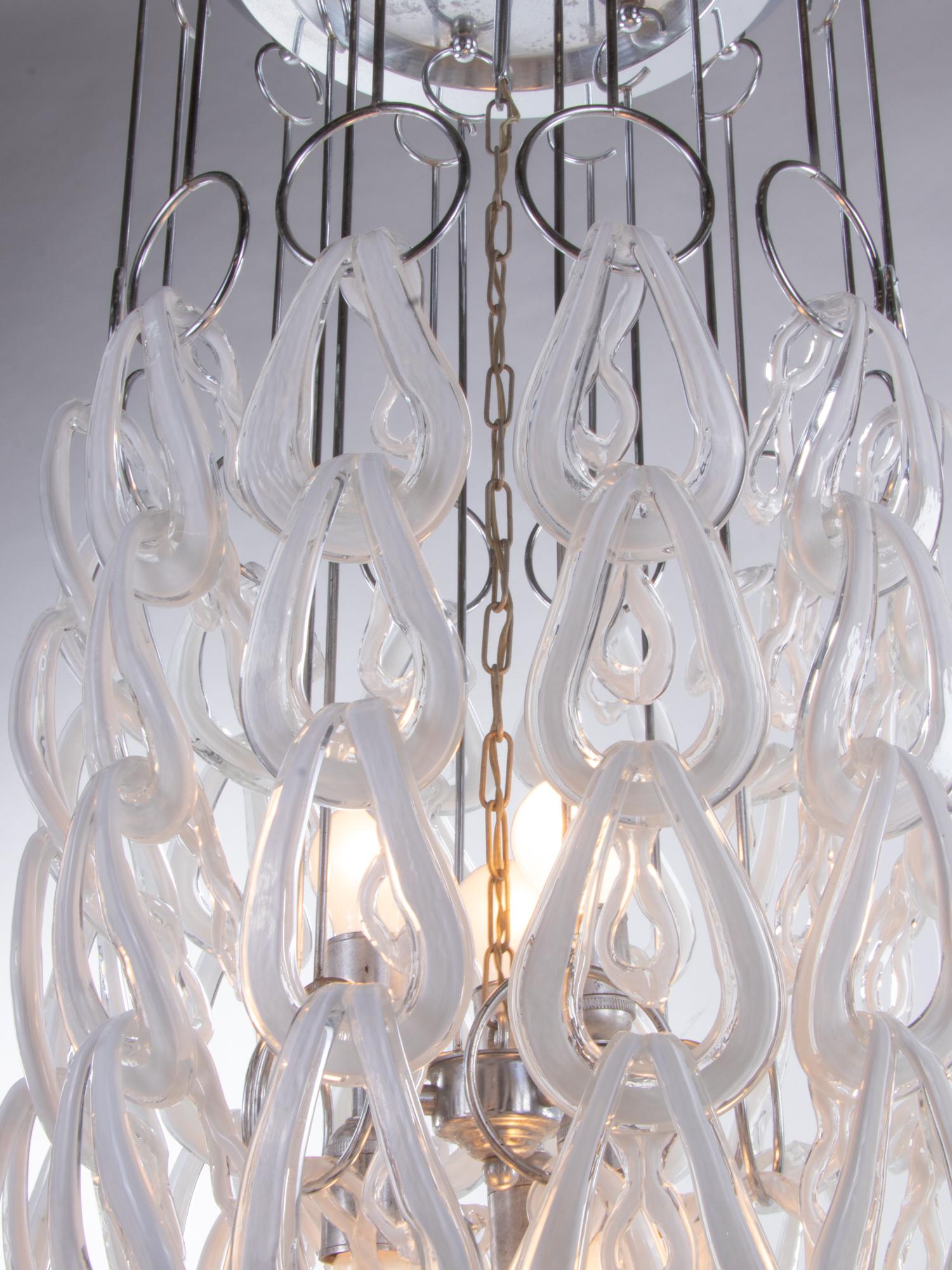 Imposing huge Giogali chandelier with numerous interlaced clear-white Murano glasses on a chrome frame. The elegant Murano glasses can be individually arranged, so that the chandelier can be adapted to different environments room heights according