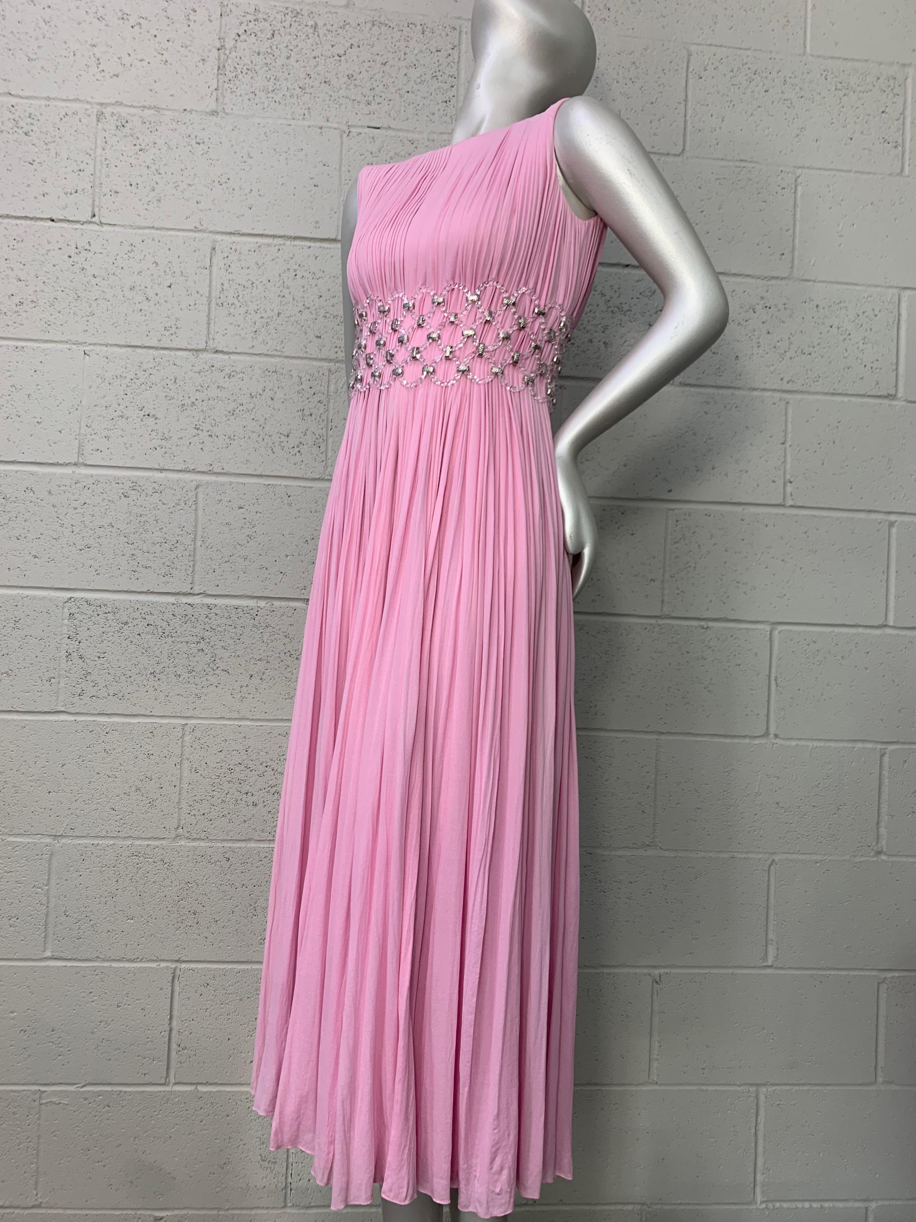 A gorgeous 1960s peony pink Jean-Louis sheer silk jersey sleeveless gown with unusual lucite ring and metal mesh waist panel. Entire gown is knife pleated the entire length. Fully lined in a fitted rayon crepe sheath. Back zipper. Heavenly! Size 6. 