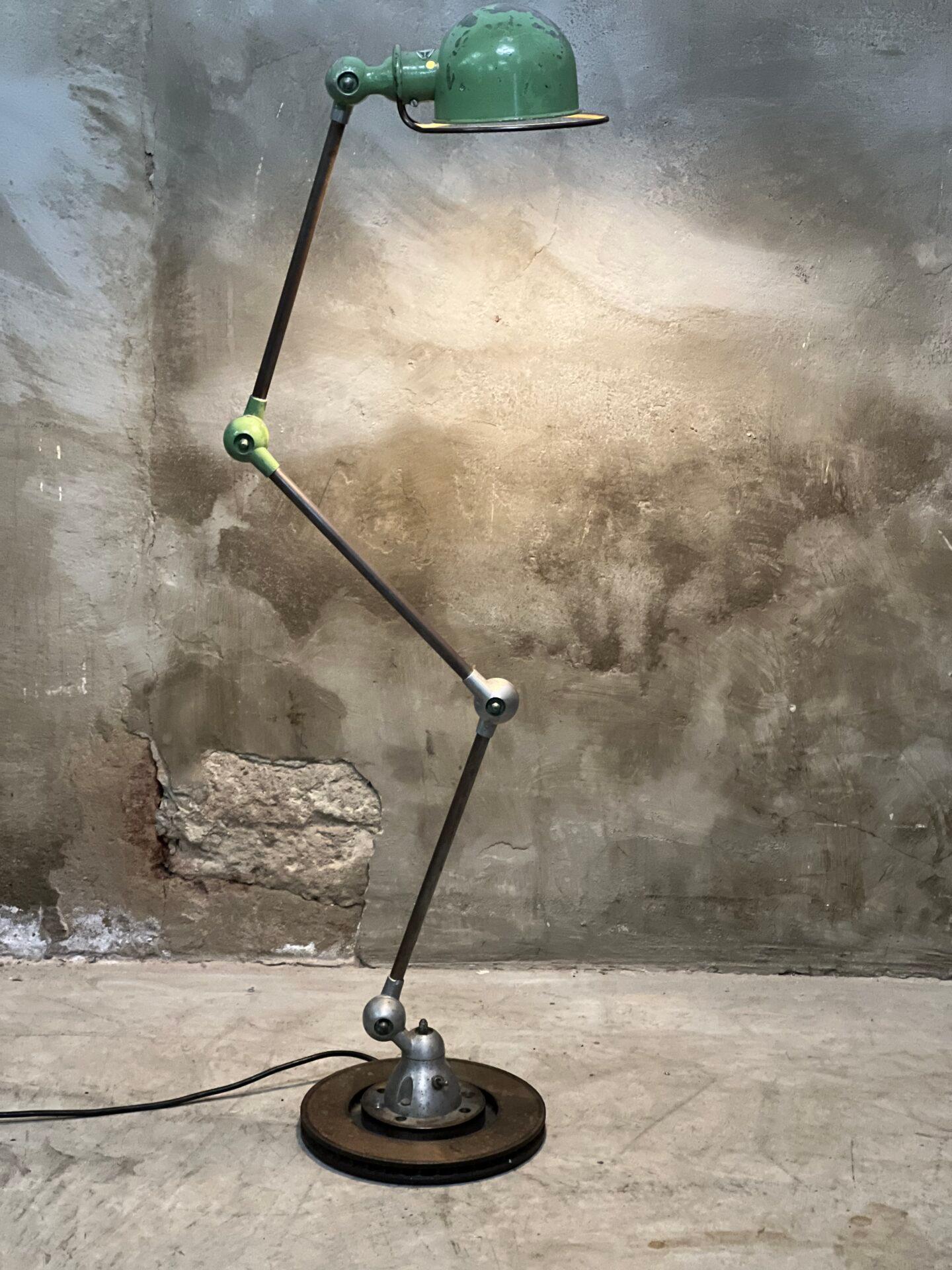 Beautiful industrial design classic, this original French Jieldé 3 arms floorlamp or reading lamp. 1960s. Original color green and beautifully lived.

Has been rewired, mounted on brake disc (used to be a clamp lamp for the workbench). Normal E27
