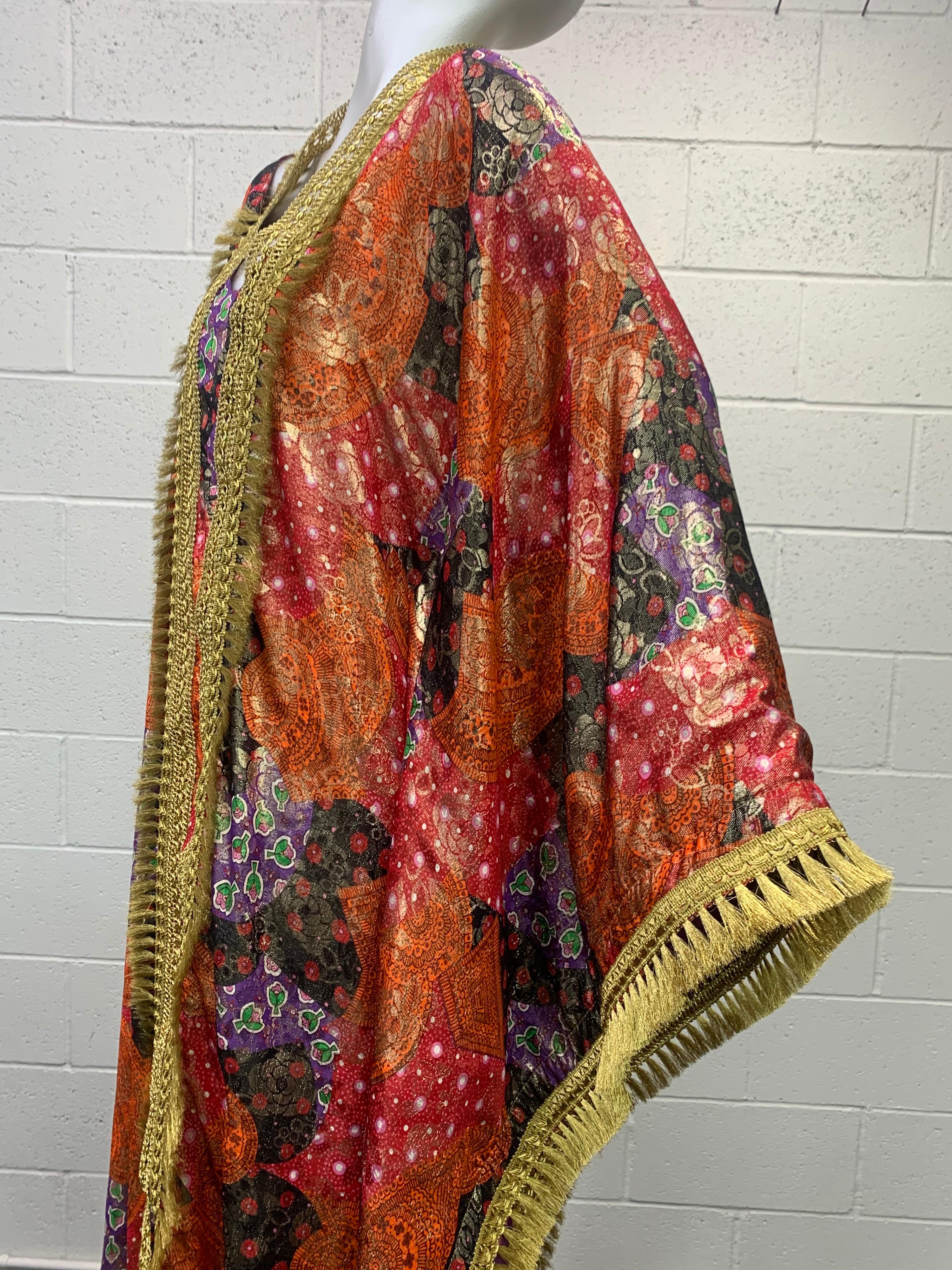 1960's Exotic gold brocade floral print voluminous Caftan features heavy brass braid trim and brass tassel at sleeves and bodice . The brocade fabric features vibrant colors of orange, red, purple , black and green in a floral motif design.

The