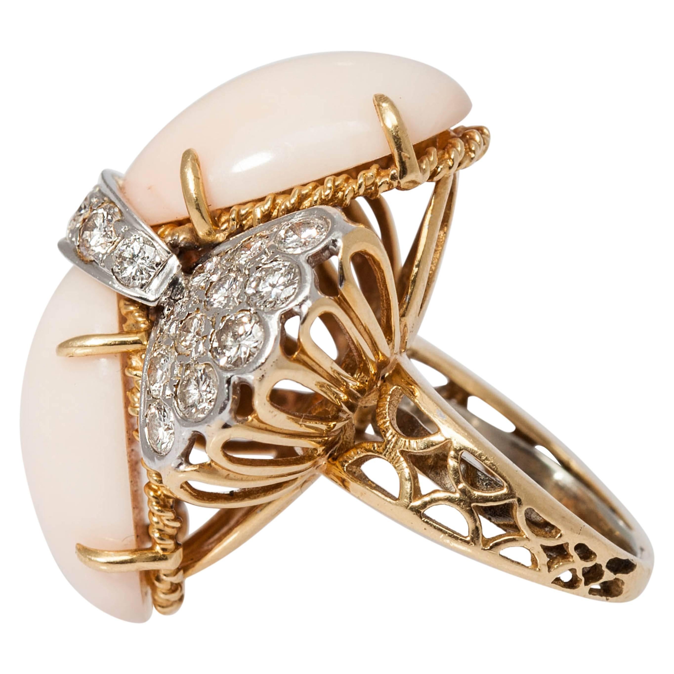 A sophisticated wing shaped cocktail ring, embellished with fine brilliant cut diamonds and two oval light coral elements. Mounted on 18kt yellow and white gold. Circa 1960. 