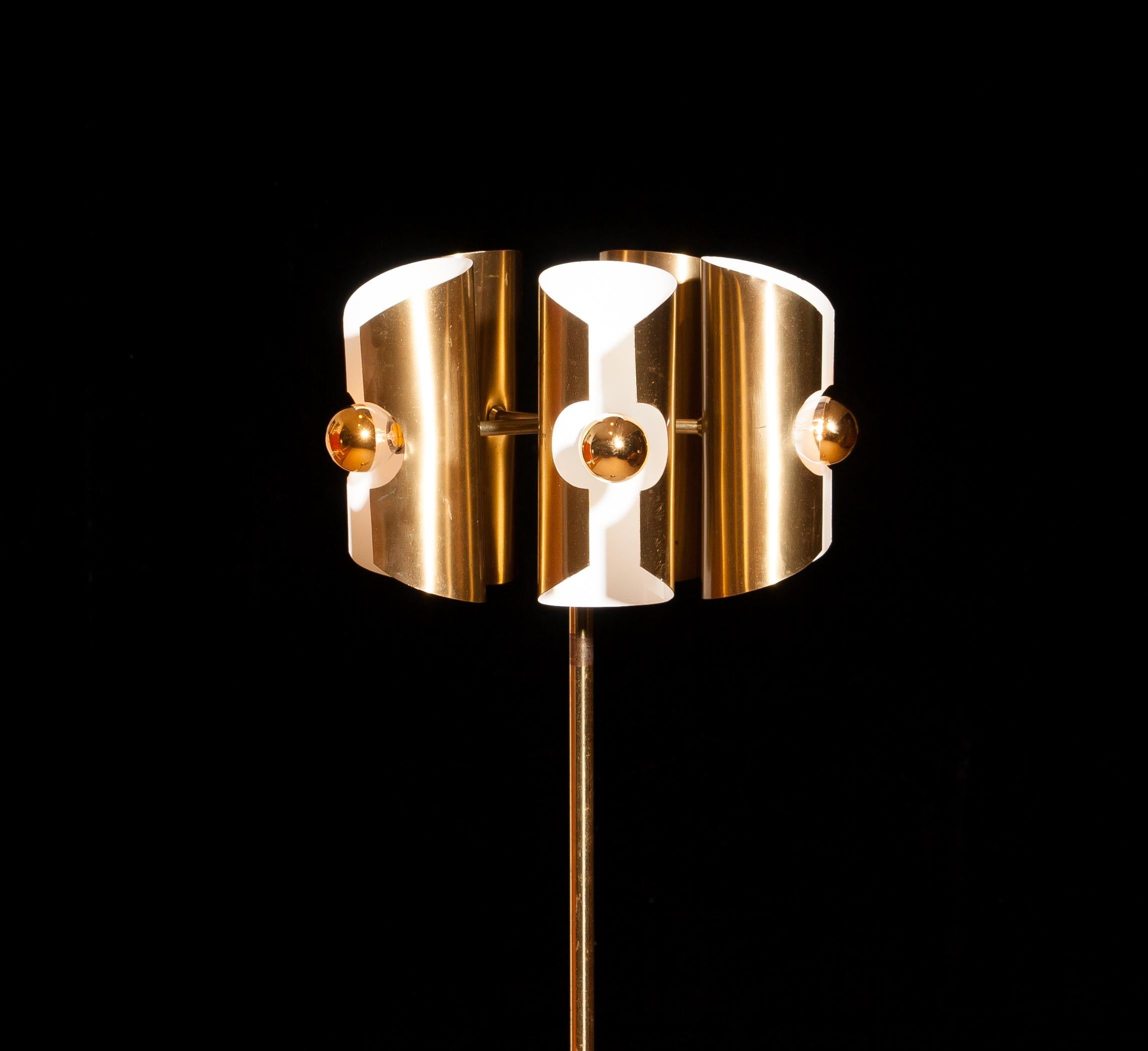 Beautiful 1960 Italian floor lamp in brass. 
The shades are fixed and made of brushed brass. 
The shades are height 21 cm. and ø 9 cm. 
Inside the shades are white lacquered for proper reflection.
The floor lamp has traces of rust, dents and