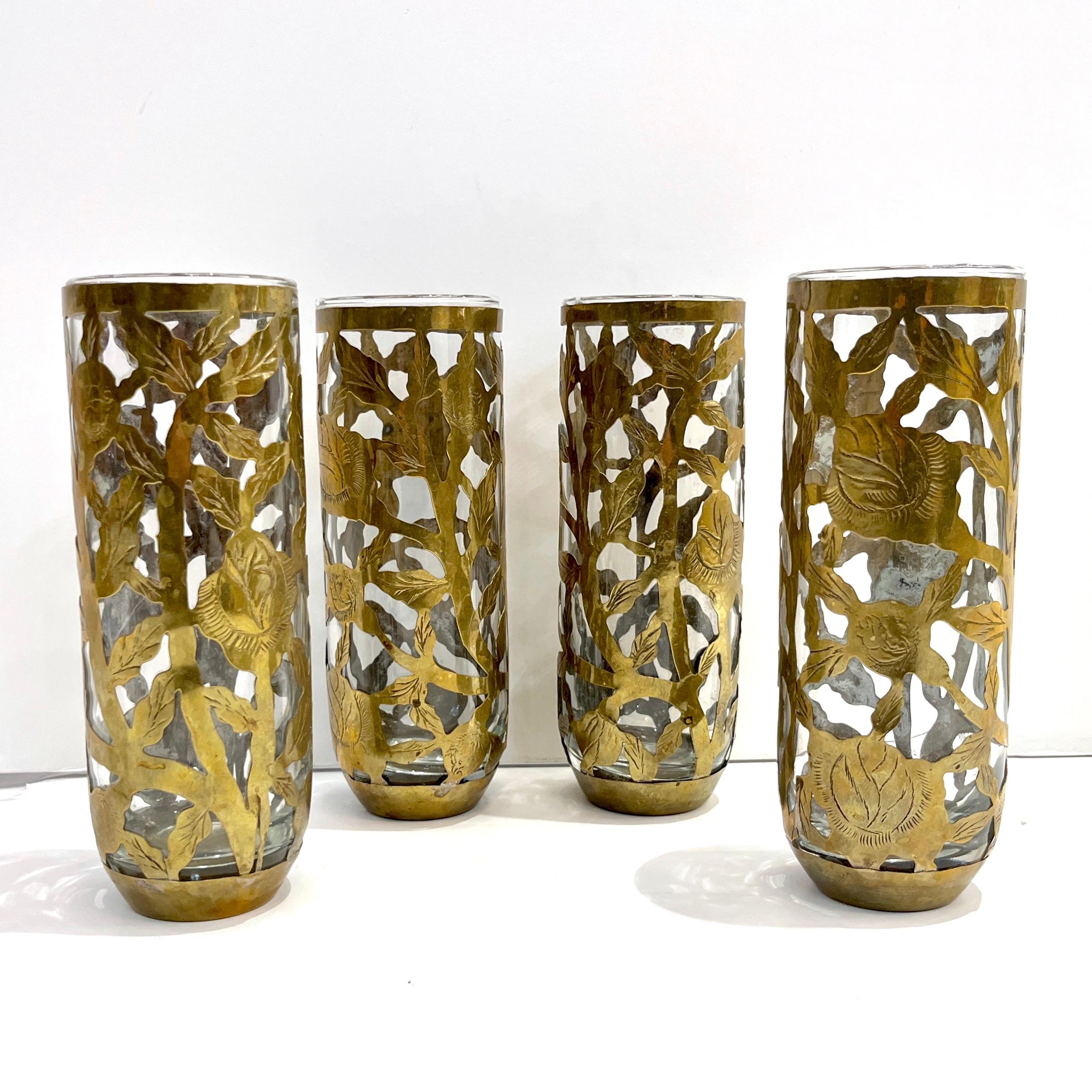 1960s mid-20th century set of 4 organic glasses, entirely handcrafted in Mexico, overlayed in a handmade antique brass open sheath, ornated with an etched cutwork floral and foliage decor.
Idéal pour le bar, mais aussi comme vase individuel pour les