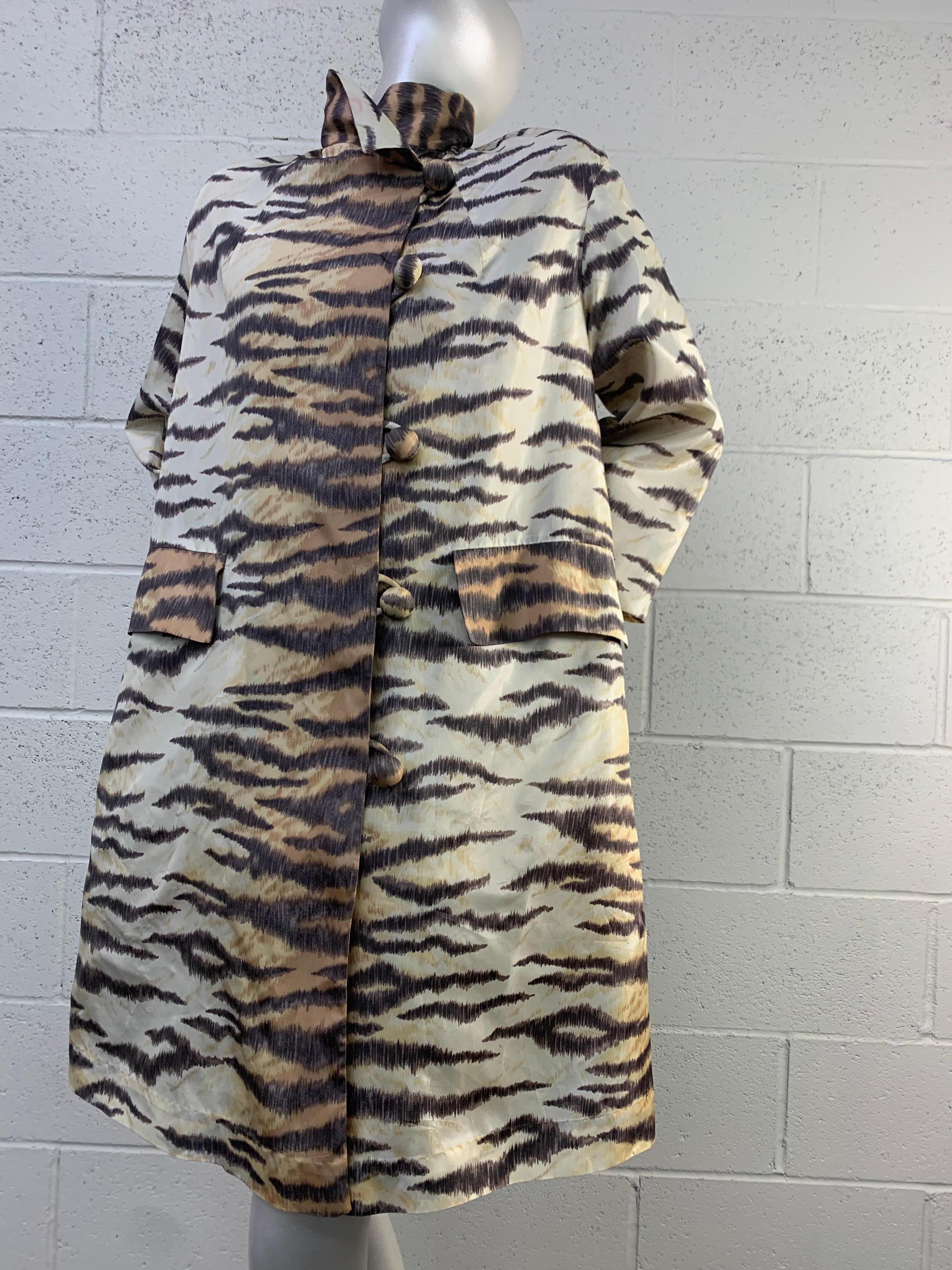 1960s Mod tiger print silk raincoat by Rain-Paka: A simple, straight cut in the body shows off the wonderfully realistic tiger print with front flap pockets and loop and fabric button closure. Fully lined. Size 8-10