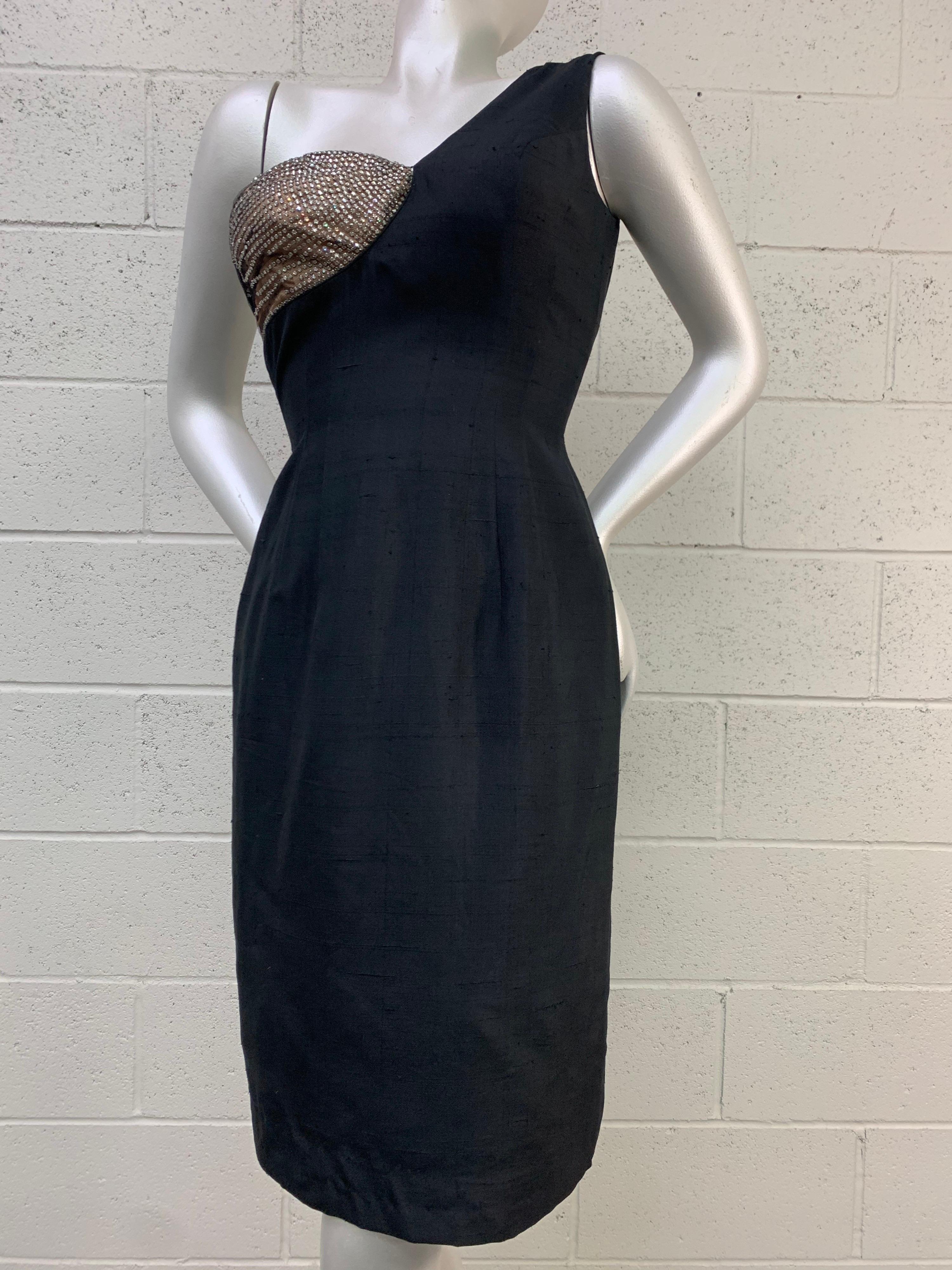 1960 Mr. Blackwell Black One-Shoulder Silk Sheath Dress w/ Rhinestone Bust: This rare and spectacular asymmetrical bust black cocktail sheath dress is covered on one breast with silver rhinestones on a structured and wired nude cup. Cut in the