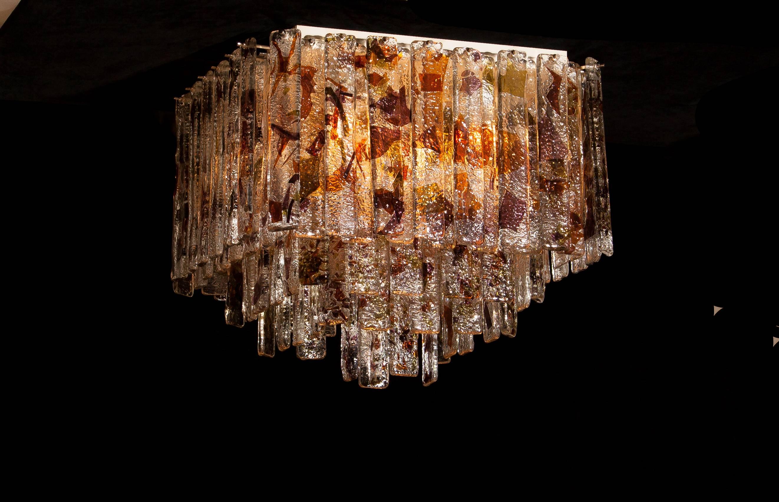 Stunning Italian Mid-Century Modern squared ceiling lamp by Mazzega. 95 pieces of clear crystal elements measuring 28cm each. The glass hangs on hooks and pins onto a white lacquered metal frame, as pictured.
The elements have three colors crystal