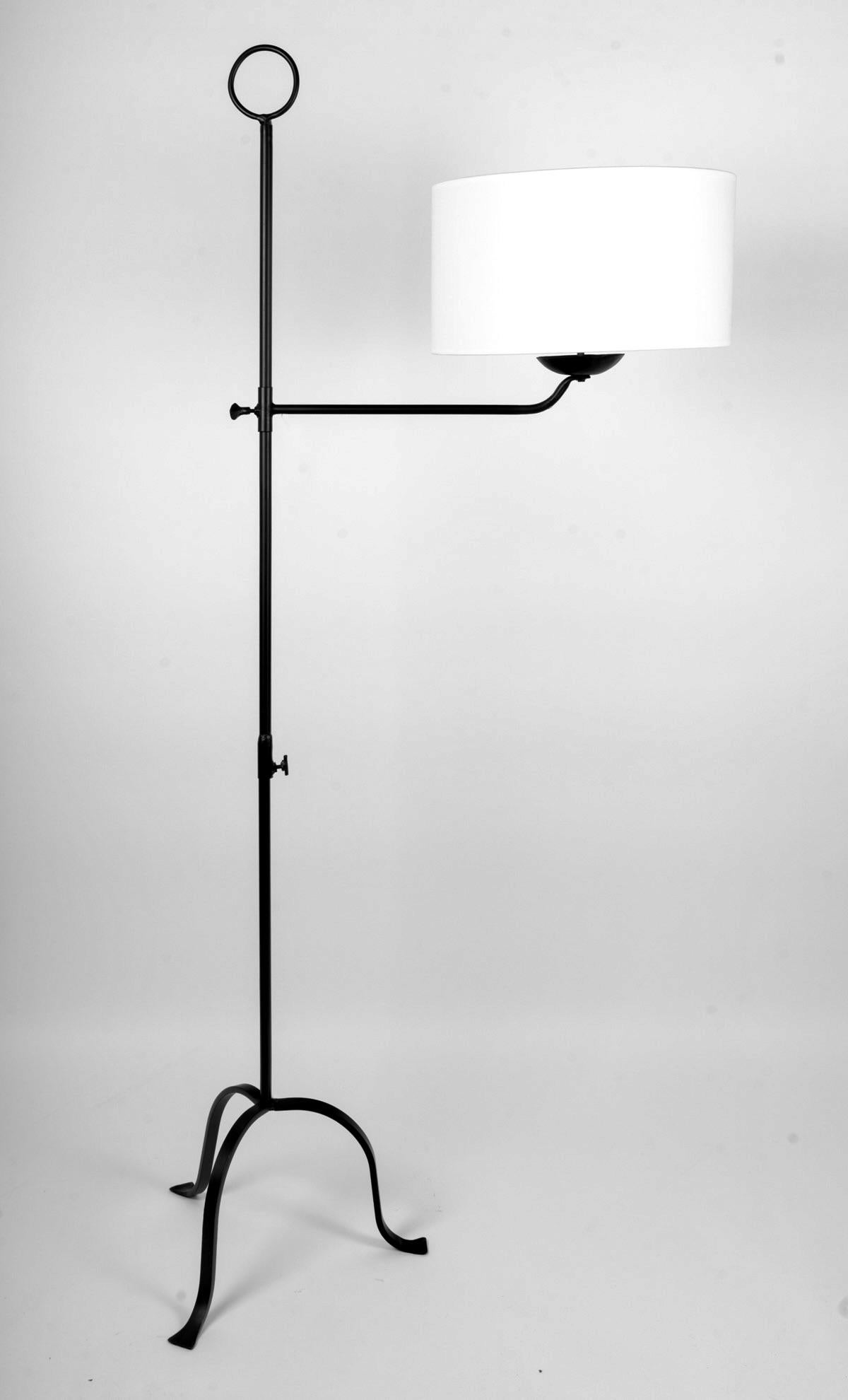 Composed of a central wrought-iron rod in two interlocking pieces of round cross-section, resting on a tripod formed by flats slightly flared at the base.
The light arm is attached to the central rod by a height-adjustable ring with clamping screw.