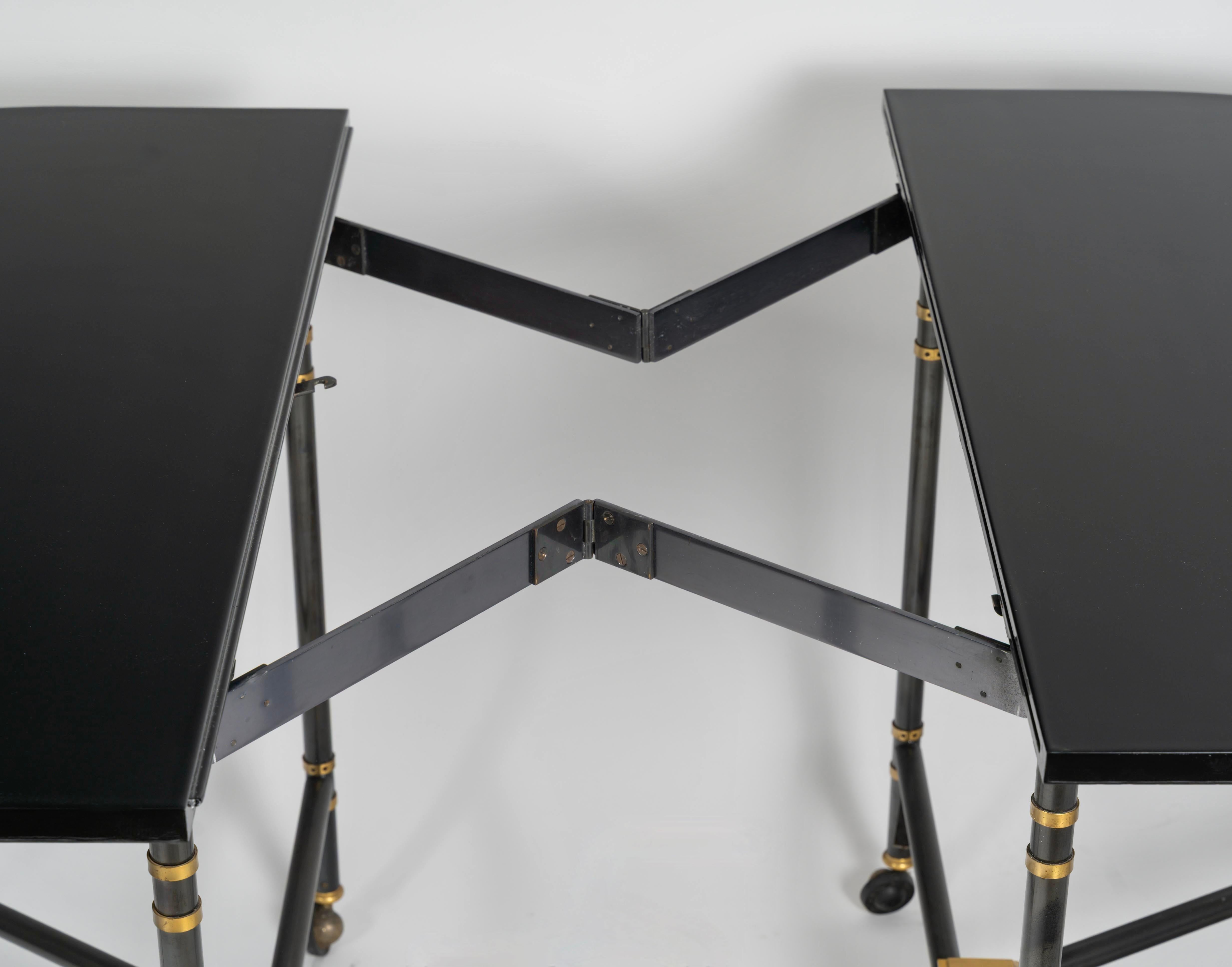 Table à rallonge ovale, modèle Royale, pièce emblématique de la Maison Jansen France, 1960.
Table avec plateau laqué noir et rallonge.
Pieds à double col et poignets en laiton. Estampillé sur les roulettes en laiton : 