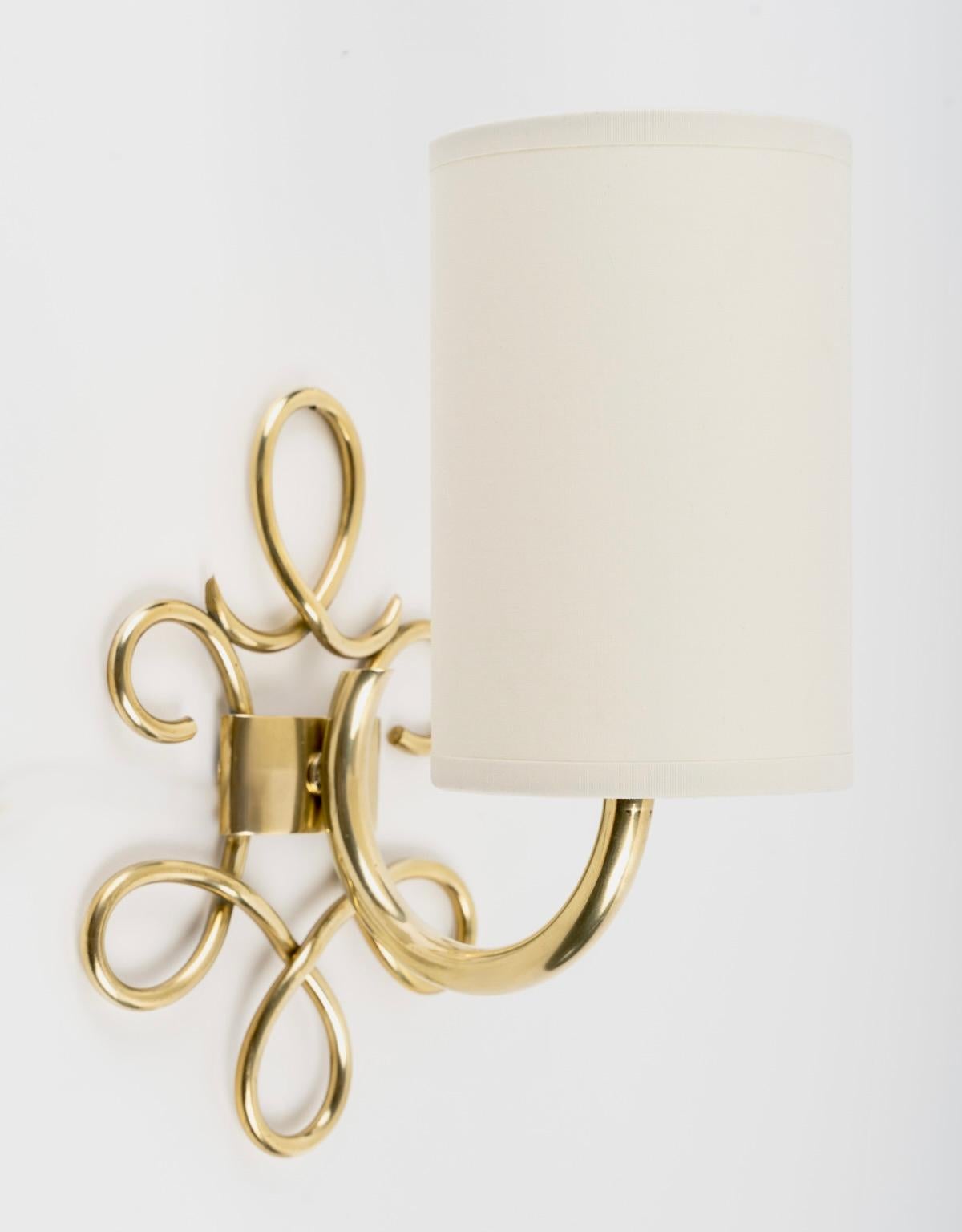 Lovely pair of loop sconces in gilded brass.
Composed of a rectangular wall support on which rests a series of loops made of fine gilded brass rods distributed around the perimeter of the wall support.
On the top and positioned in the center, a
