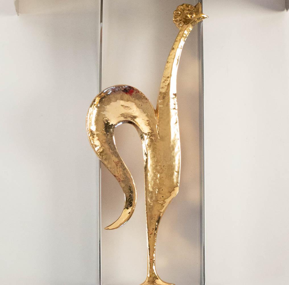 Composed of a rectangular frame in silver plated brass, inside the frame is a decoration composed of a rooster on its stylized perch in partially hammered gilt bronze.
The sconce is dressed with a lampshade in silver plated brass of origin.

Two