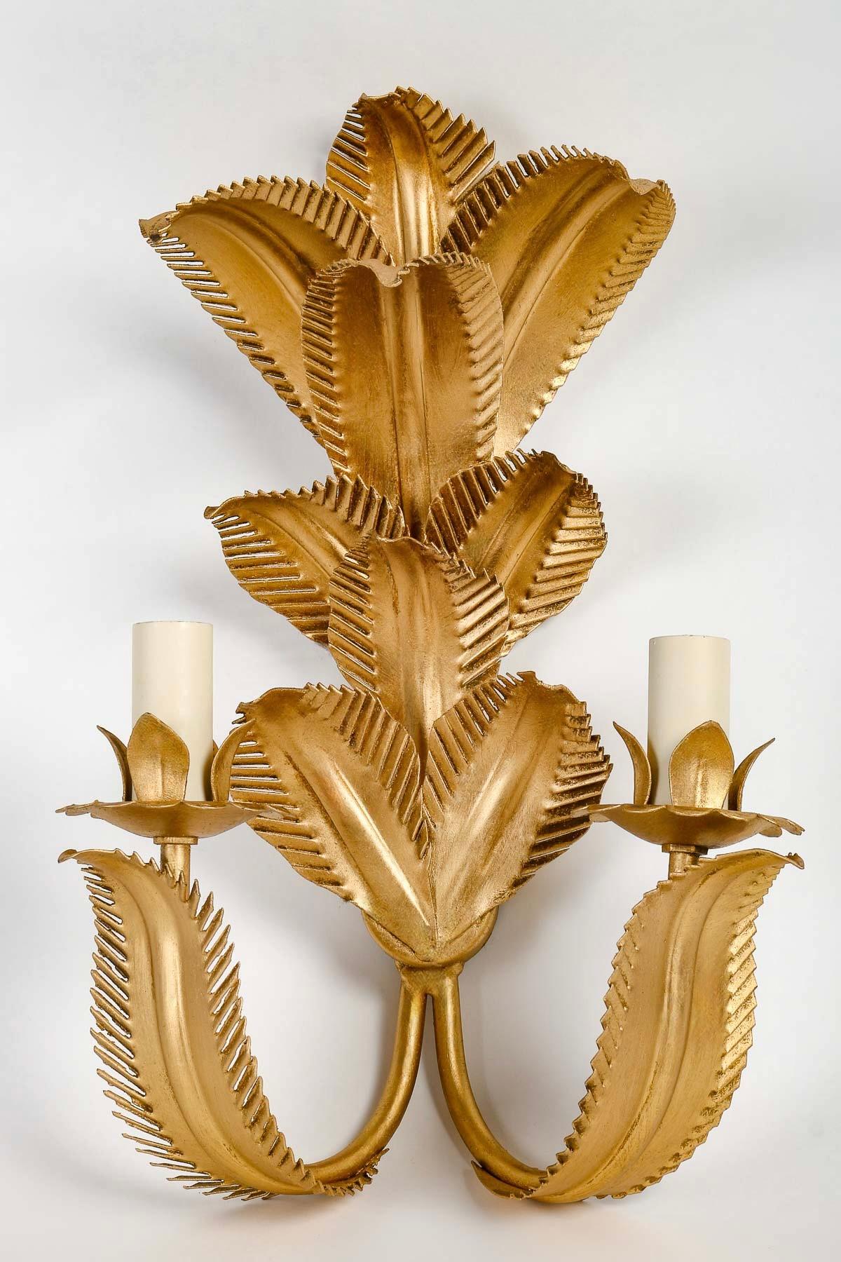 Composed of palm leaves arranged at 3 different heights in gilded metal forming the wall support.
On the lower part of the sconce, two arms of light on either side of the sconce are embellished with foliage and adorned with two illuminating candles