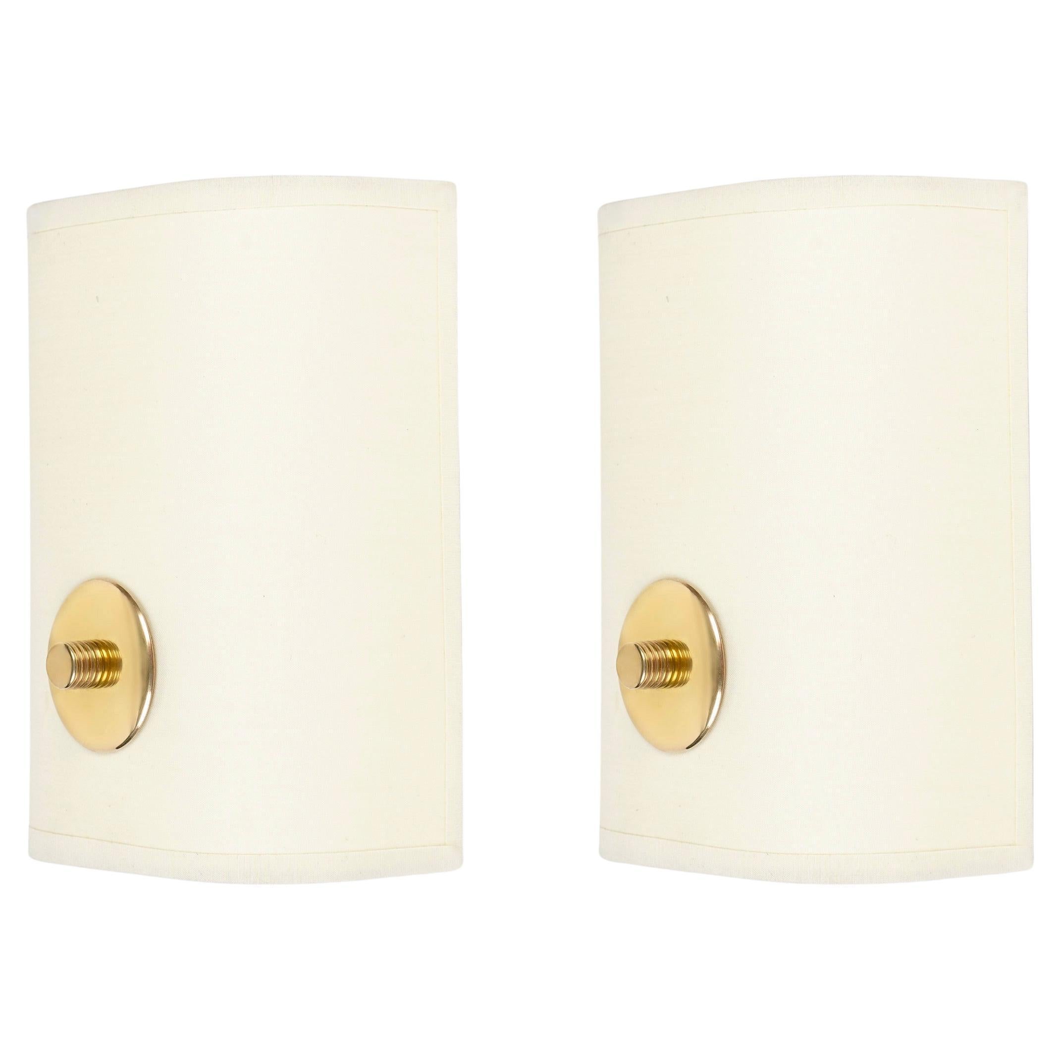 Composed of a rectangular screen laid vertically in off-white cotton, adorned on the lower part of the sconce's front face with a disk fitted with a cylindrical screw in gilded brass supporting the whole.

1 light arm.