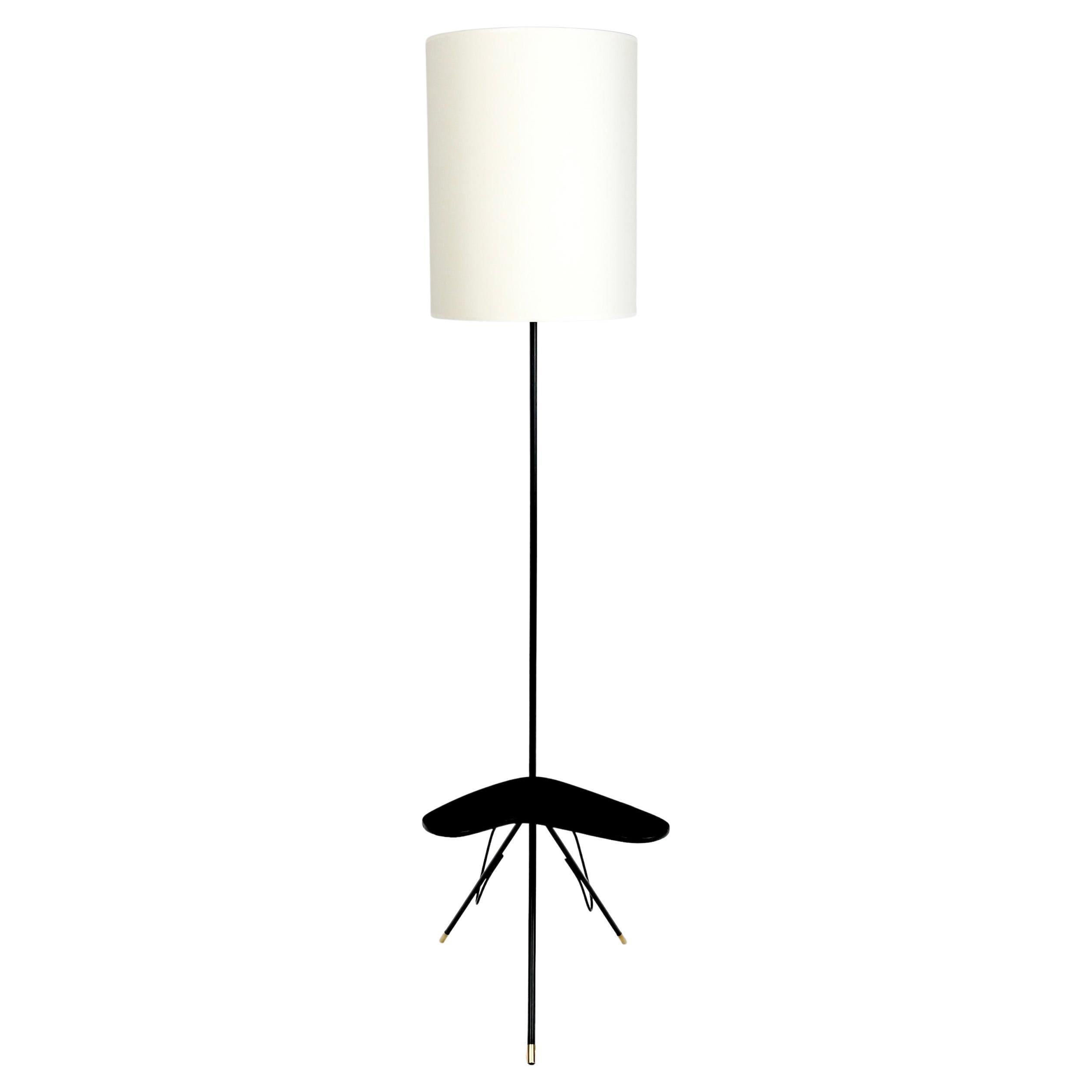Composed of a central rod dressed on the upper part of a cylindrical shade of off-white color redone identically.
On the lower part the stem curves to form a part of the foot, it supports a shelf in the shape of heart in black lacquered wood.
The
