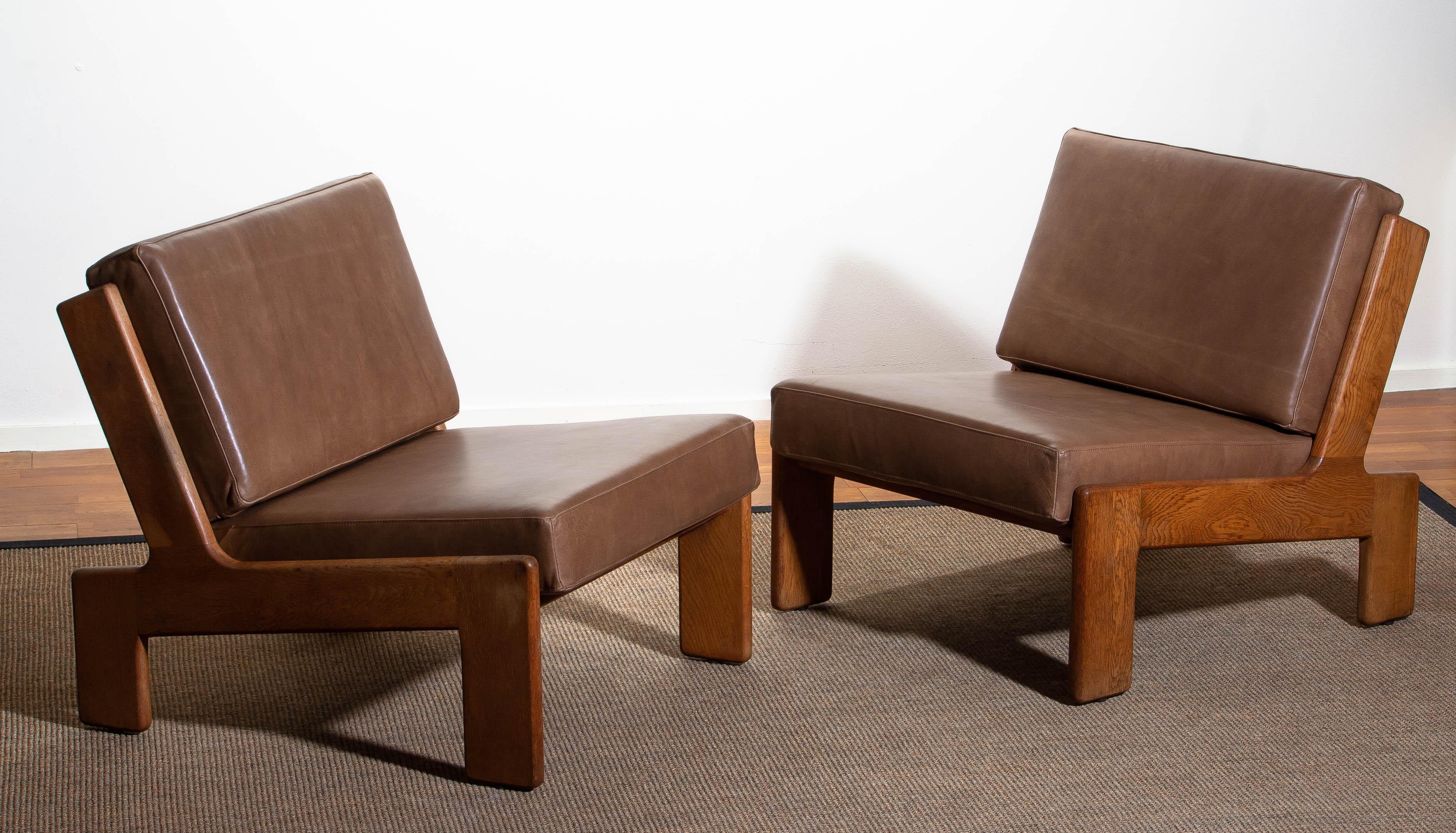 1960s. Set of two extremely rare cubist lounge /easy chairs designed by Esko Pajamies for Asko Finland in oak and leather.
The cushions of both chairs are newly upholstered with leather. Also the bindings are replaced.
The overall condition of