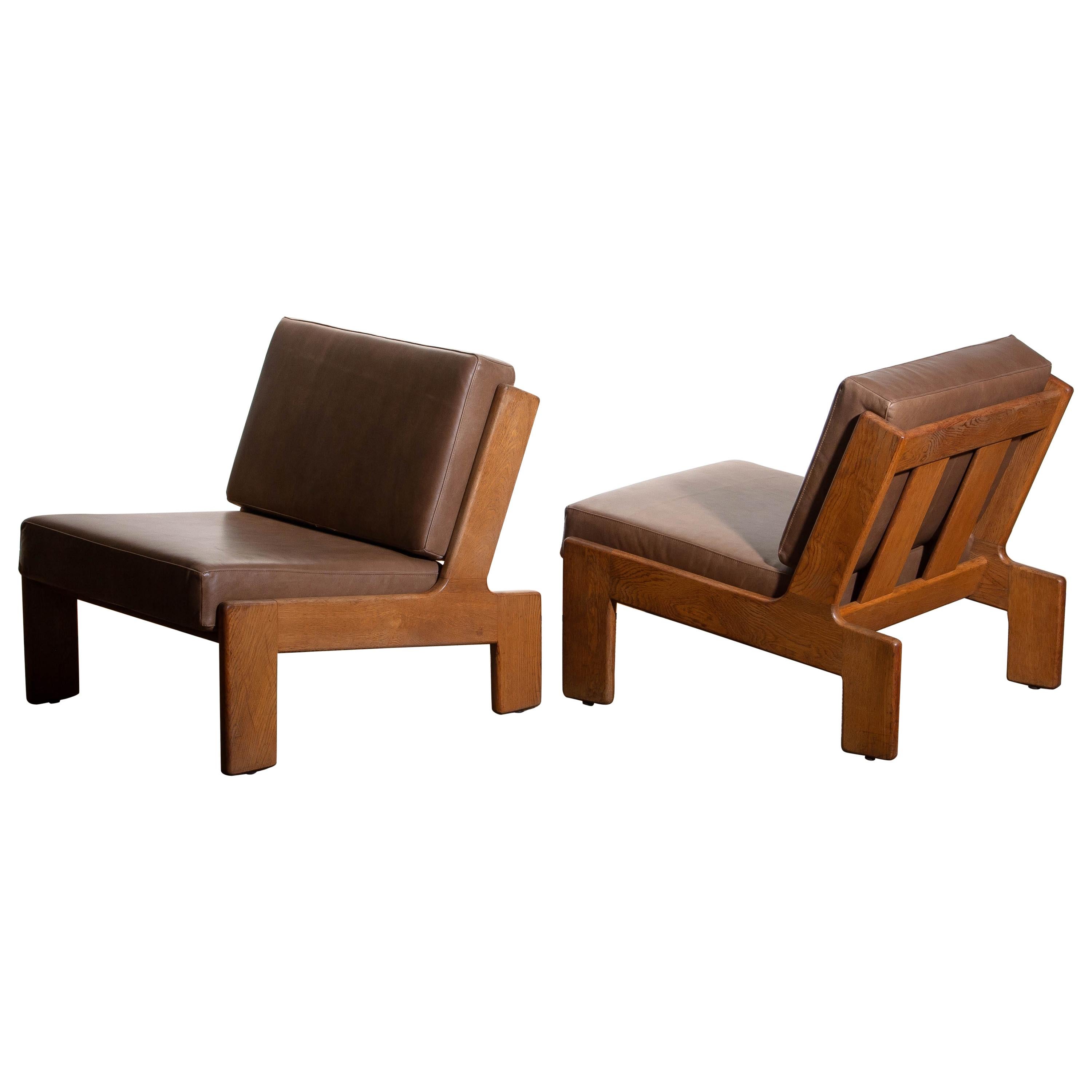 1960s set of two extremely rare cubist lounge /easy chairs designed by Esko Pajamies for Asko Finland in oak and leather.
The cushions of both chairs are newly upholstered with leather. Also the bindings are replaced.
The overall condition of this