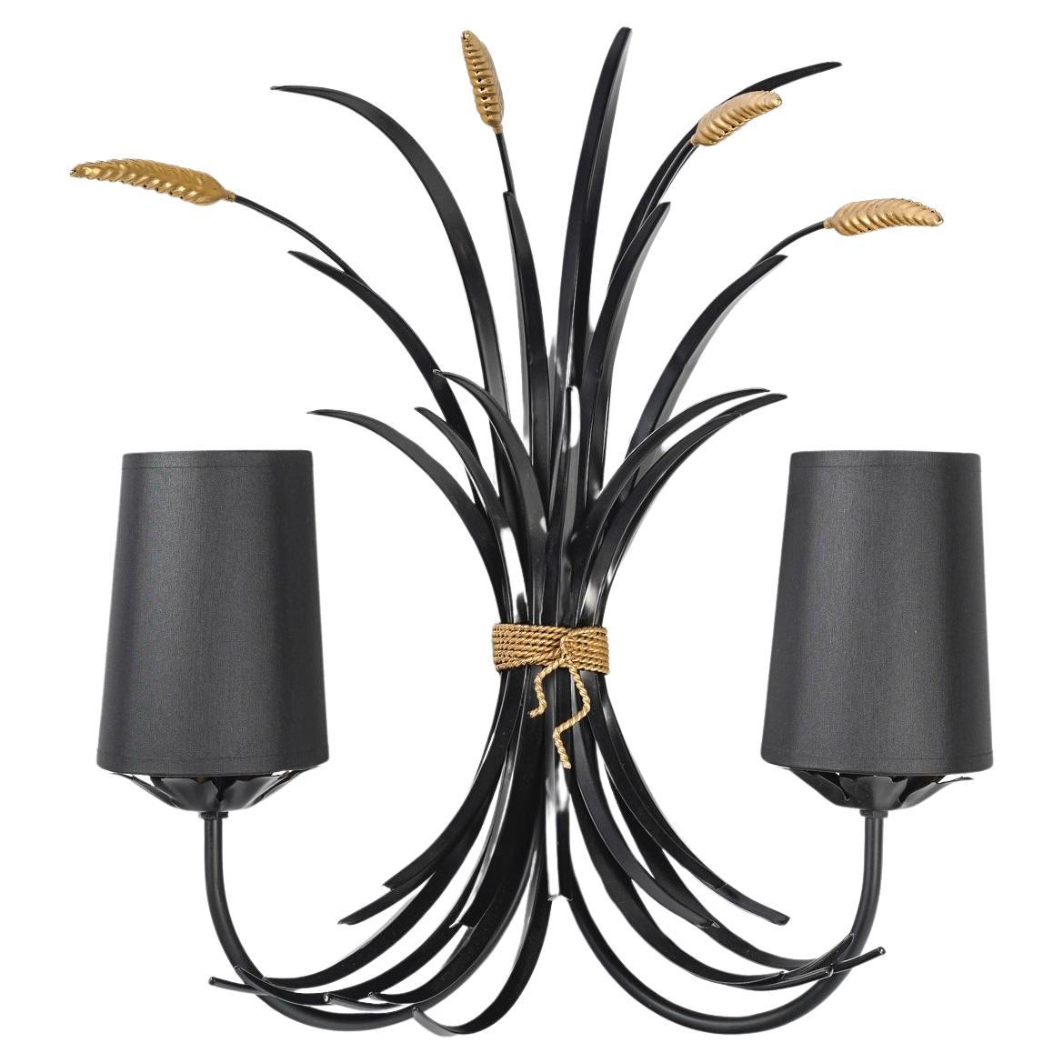 Wheat bouquet in black and gold metal, composed of black foliage and gold ears of wheat assembled by a pretty knot imitating twisted gold rope.
On the lower part, two arms of light positioned on either side of the sconce are dressed in black cotton