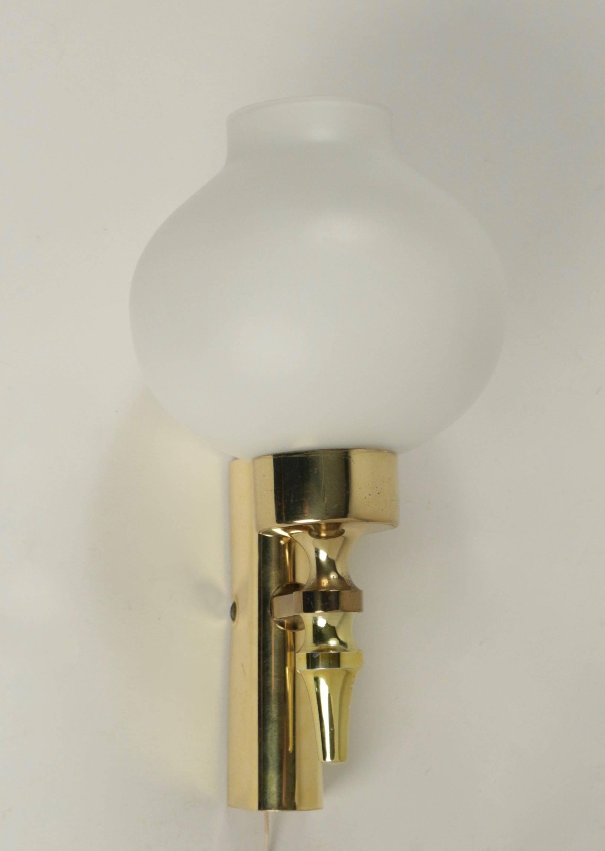 
Composed of a wall support formed by a half cylinder positioned in height in gilded brass.
From the wall base leaves a stem on the low part which support the arm of light dressed with a white satin opaline of origin put on a round cylindrical base