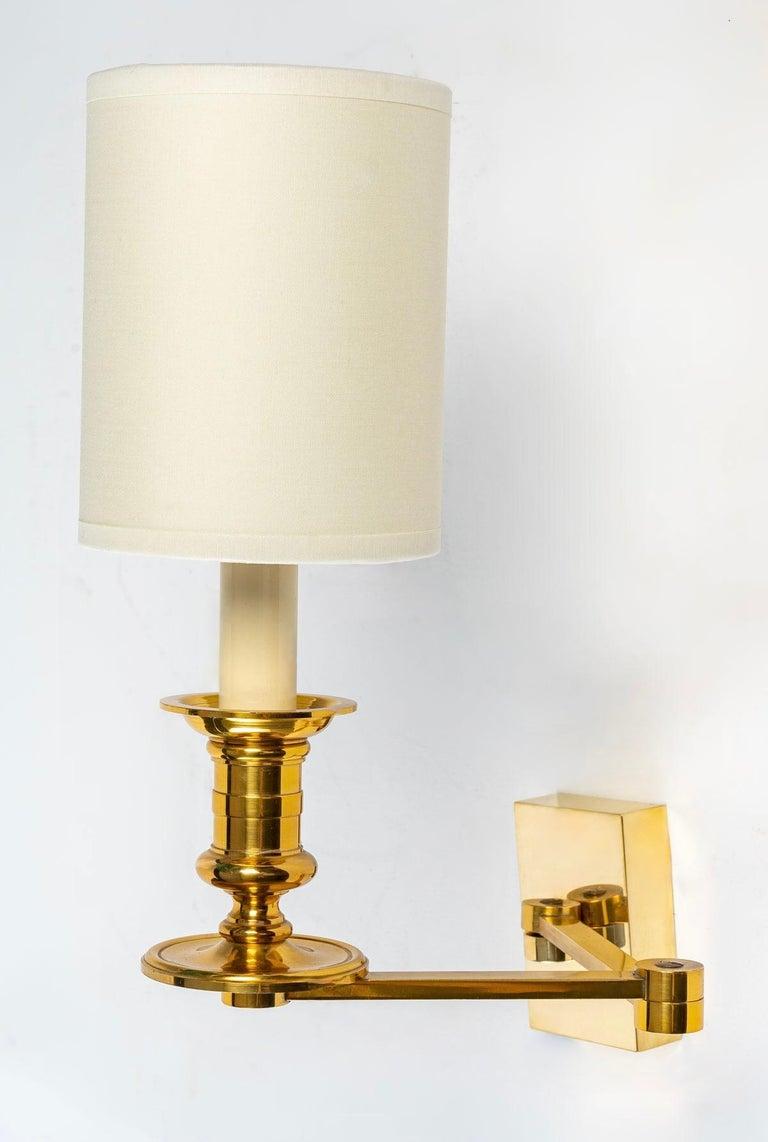 Composed of a rectangular back plate on which is positioned the arm of light composed of two rods articulated together allowing the extension of the wall lamp.
They are dressed with cylindrical lampshade in off-white cotton made to measure.

1