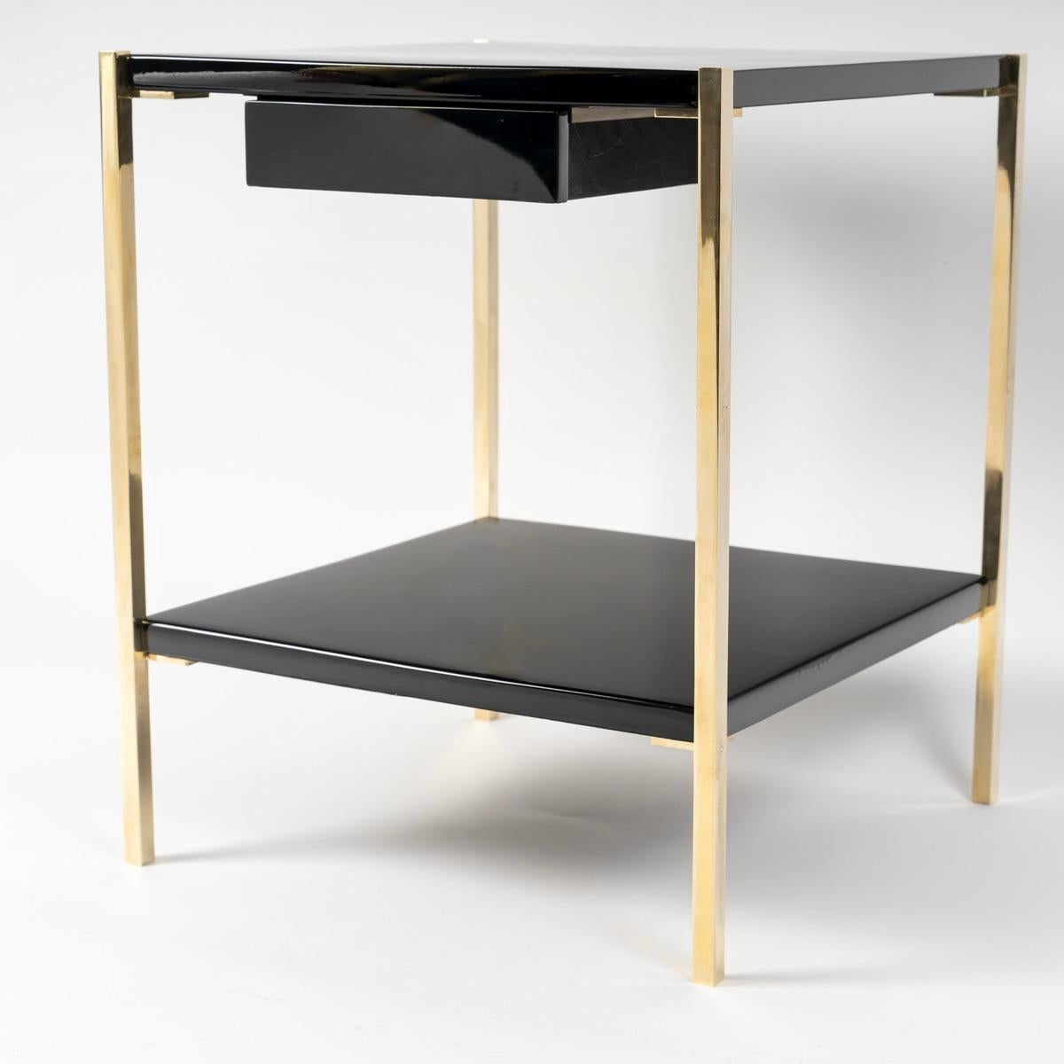 La estructura se compone de cuatro patas de sección cuadrada de bronce dorado, colocadas en las cuatro esquinas de las mesas, sobre las que descansan dos tableros de laca negra situados en la parte superior e inferior de cada mesa.
Bajo el tablero