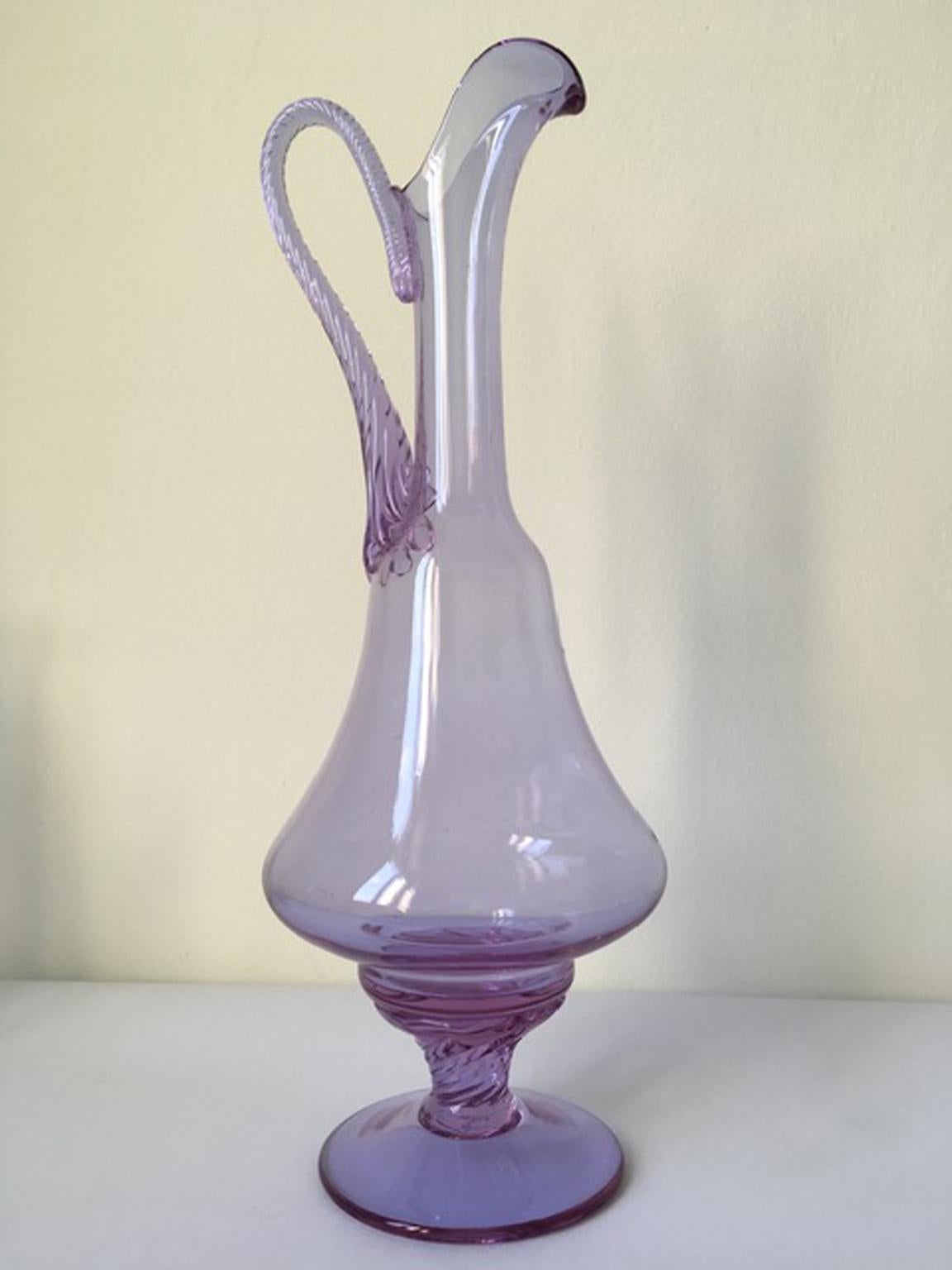 This is an elegant shaped bottle hand made in Murano, Venice in 1960 in Murano blown glass. The piece is very charming and on it are visible the signs of the handwork.
The bottle has a vibrant color, the purple color.

This piece can be part of your