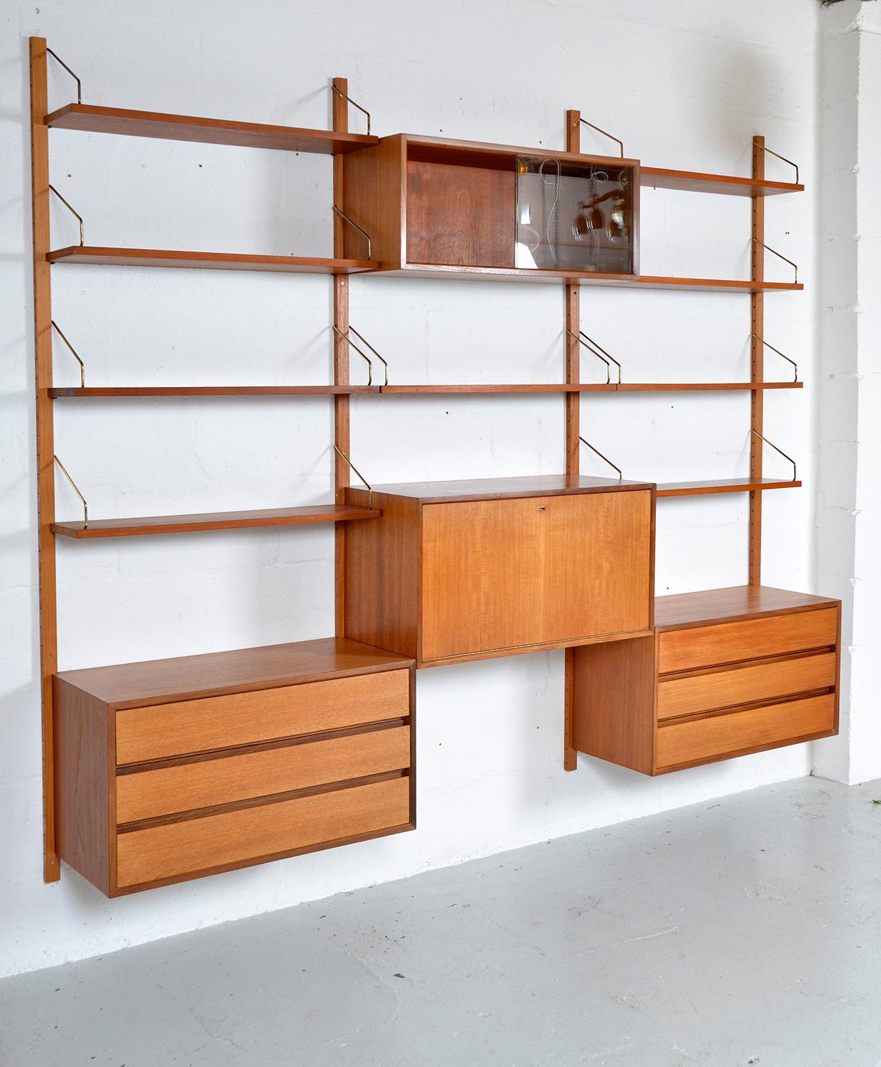 This highly versatile and functional “Royal System” was originally designed by Poul Cadovius in 1948. This three-bay teak shelving system offers a wide variety of storage and display options. 
The set includes two three-drawer chests of drawers, a