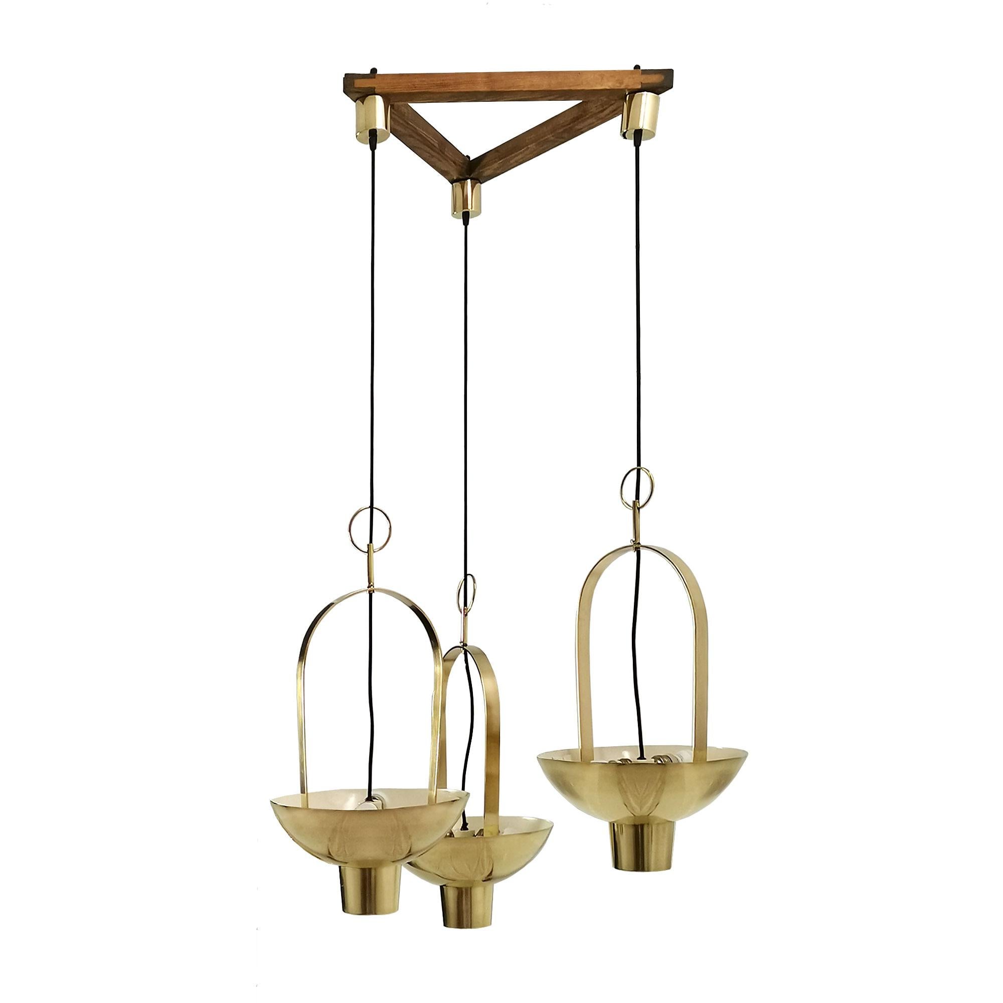 Composition of three lanterns assembled as a chandelier for a special order. Polished solid brass, ivory lacquered inside, three lights by lantern. Pine wood original structure.
Designed and made by Jordi Vilanova.

Spain, Barcelona c. 1960.