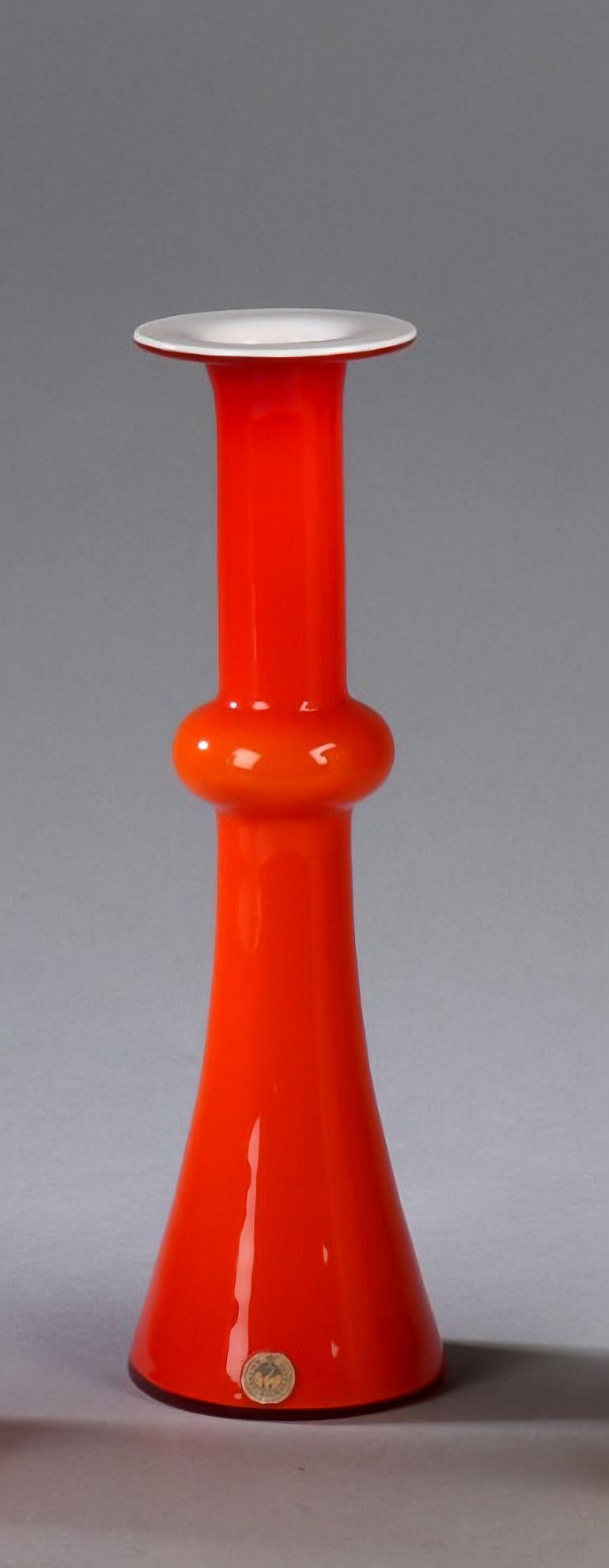 Vase soufflé à la bouche en verre opalin rouge par Christel et Christer Holmgren en 1968 pour Holmegaard.

Le vase est fabriqué en verre opale rouge vif soufflé à la main, à trois couches, avec une base en verre blanc, et porte toujours le Label