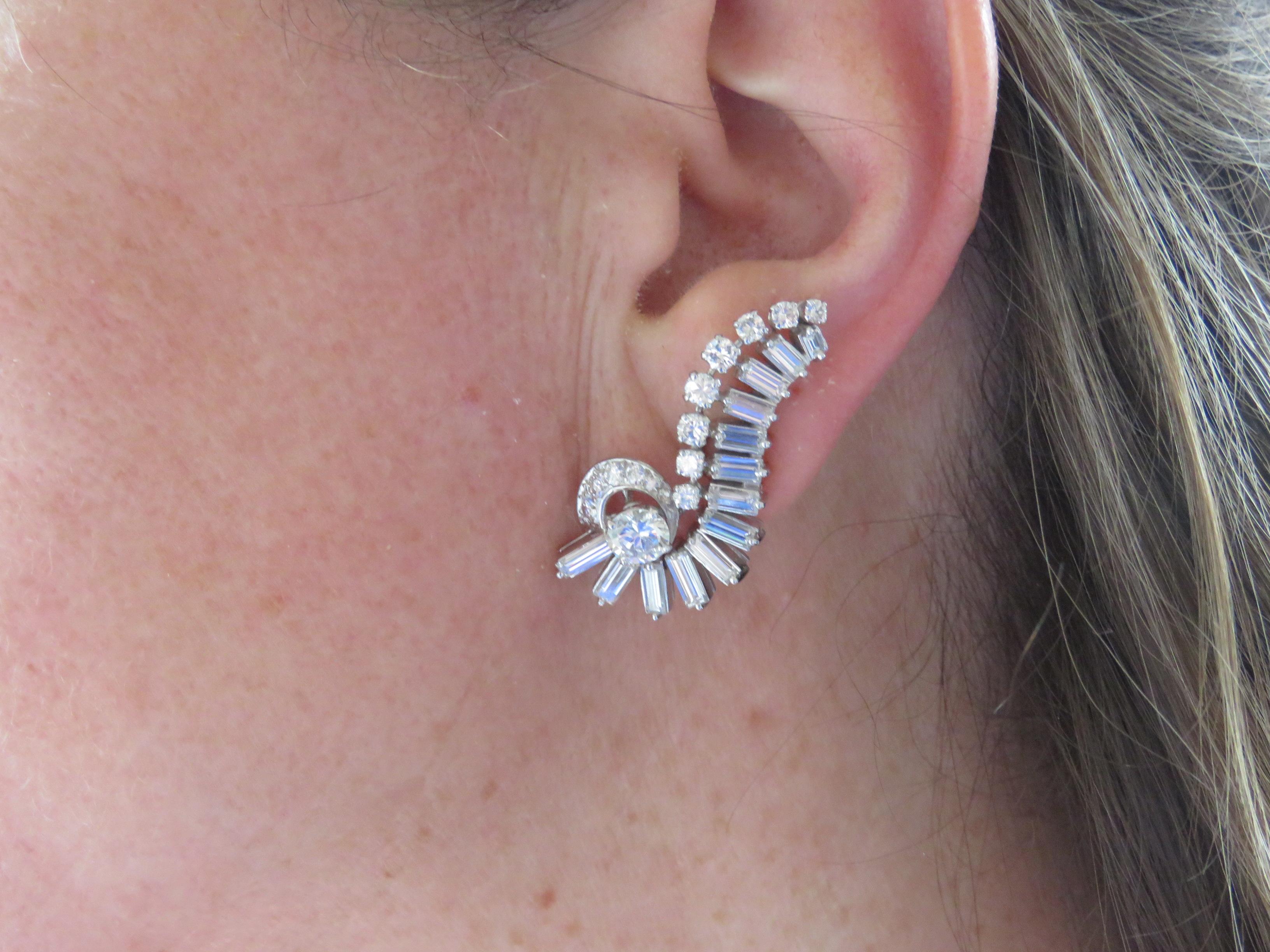 `An pair of cluster ear clips , dating back to the 1960 s ,

Set approximately 4 carats of brilliant round , baguette cut diamonds

Mounted in platinum and gold.

Dimensions:

Height: 3.40 cm     Width: 1.60 cm     Weight: 17.30 grams
