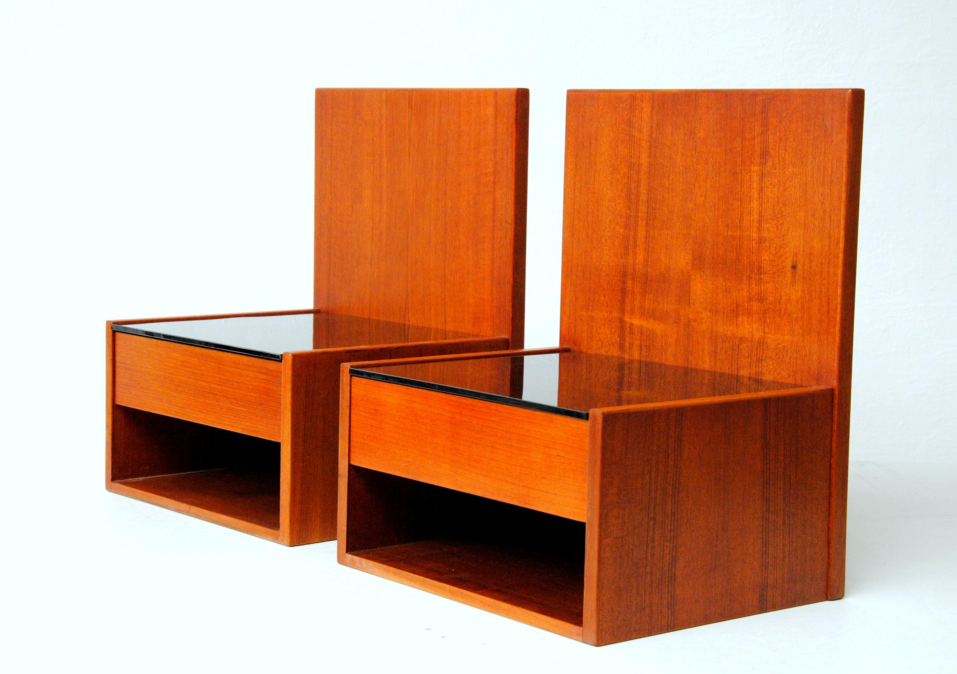 1960's Hans Wegner Set of two floating nightstands in teak with glass for Getama.

The set of floating night stands or shelves in teak, each festure a single drawer, open storage compartment beneath and a black glass table top surface, designed by