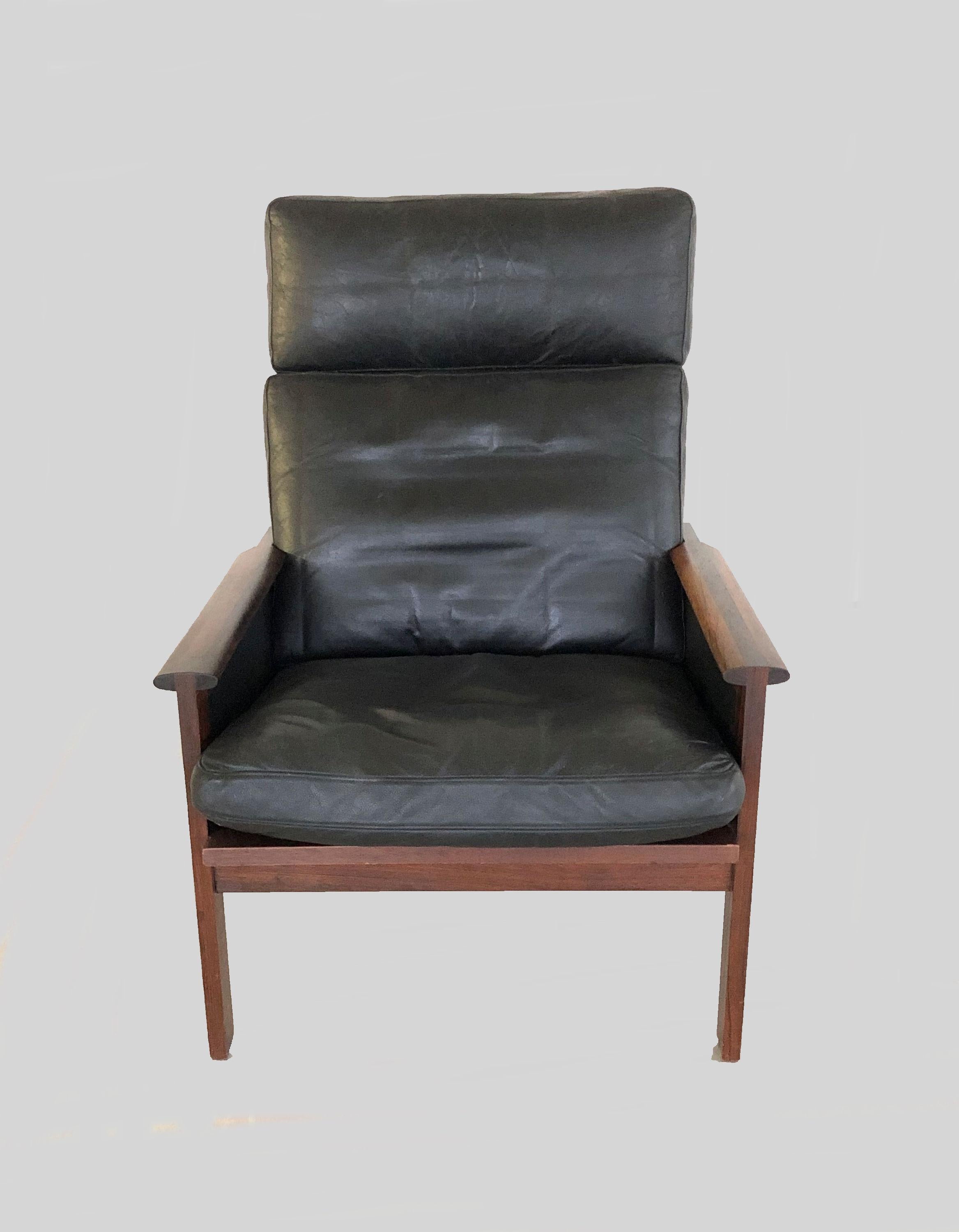 Illum Wikkelsø high back Capella lounge chair and ottoman designed by Illum Wikkelso in 1959 and manufactured in Denmark by Niels Eilersen. 

The comfortable and very well made lounge chair is made of solid rosewood with distinctive joinery on the