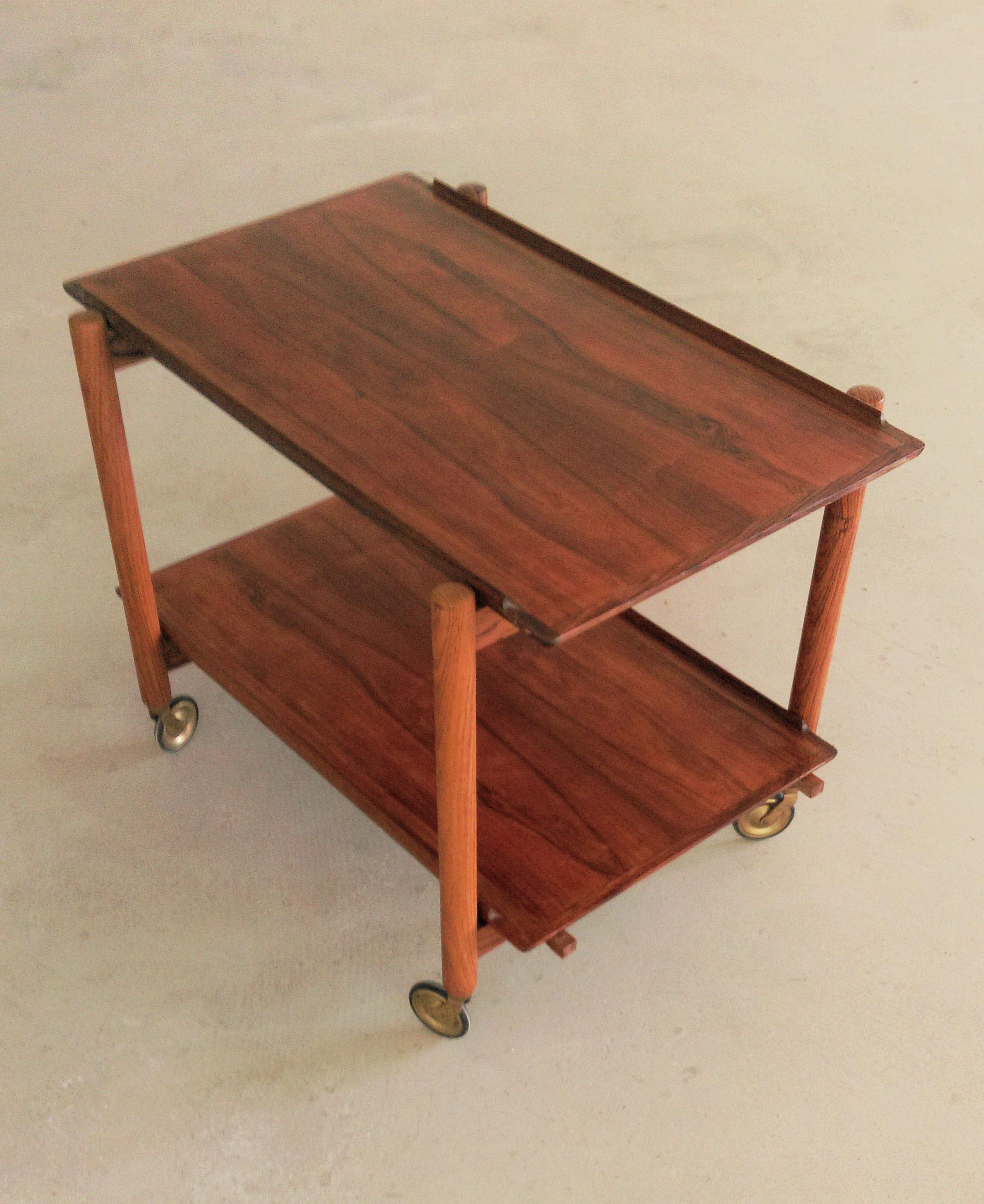 1960s Poul Hundevad Danish modular two-tiered rosewood bar cart

The flexible bar table features a unique combination of organic shapes, excellent craftsmanship and a very flexible design that enables the four wheeled table to be used for numerous
