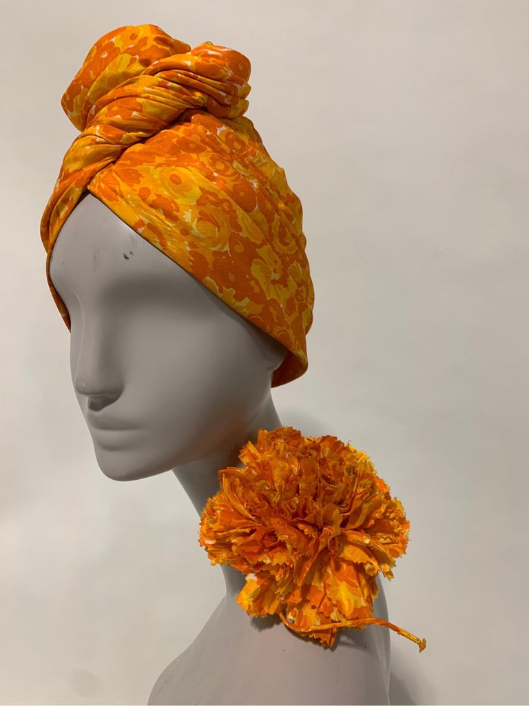 1960 Saks Fifth Avenue marigold orange and yellow silk floral print turban with high dramatic twisted knot and matching carnation fabric corsage. New, never worn. Turban is softly structured on a felt cap base inside hat. Lovely original set really