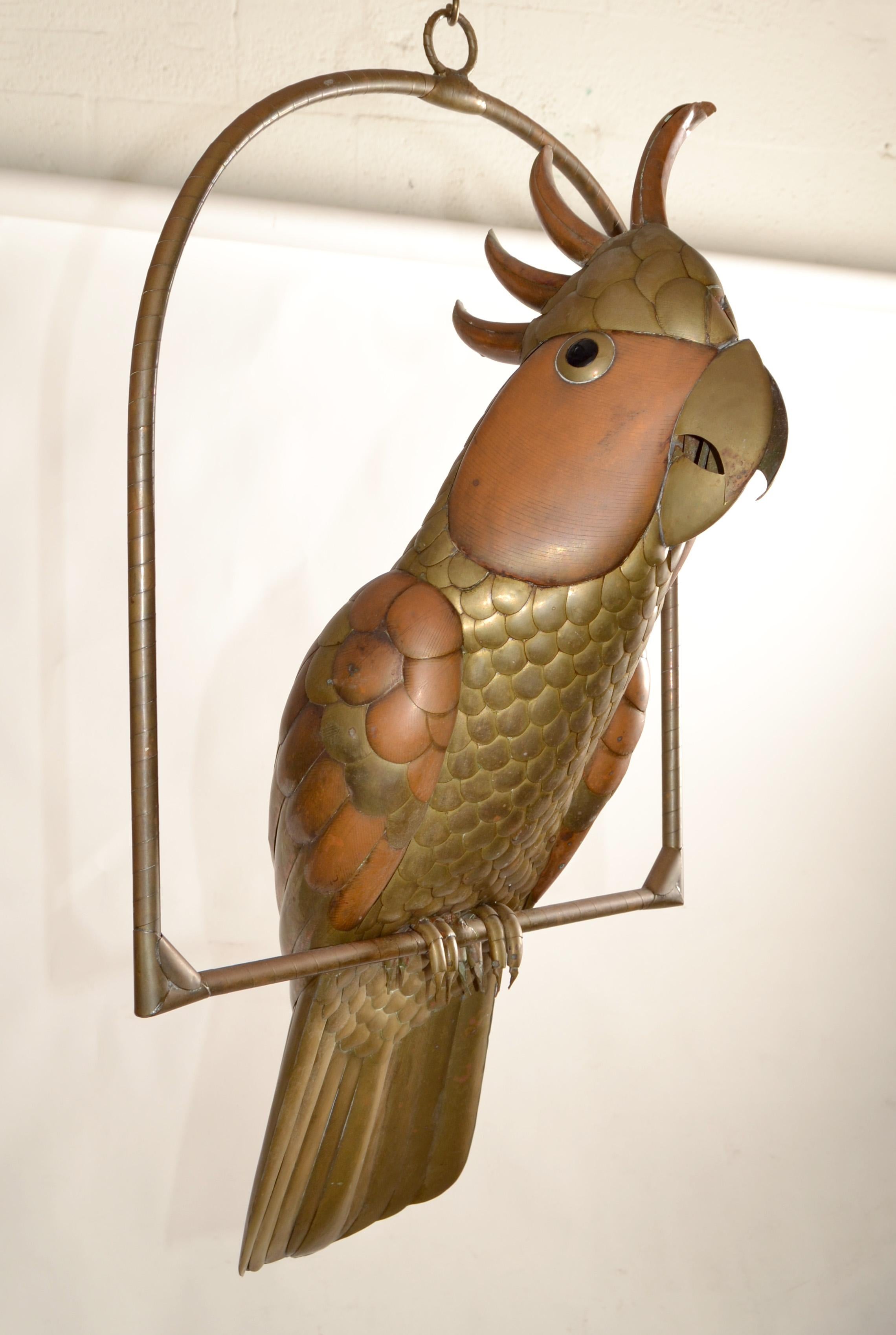 Splendida e dettagliata scultura di pappagallo cacatua realizzata in rame, ottone e alluminio su un supporto appeso a cerchio da Sergio Bustamante, circa 1960.
Con piume scolpite singolarmente e una sorprendente finitura in ottone lucido.
Un