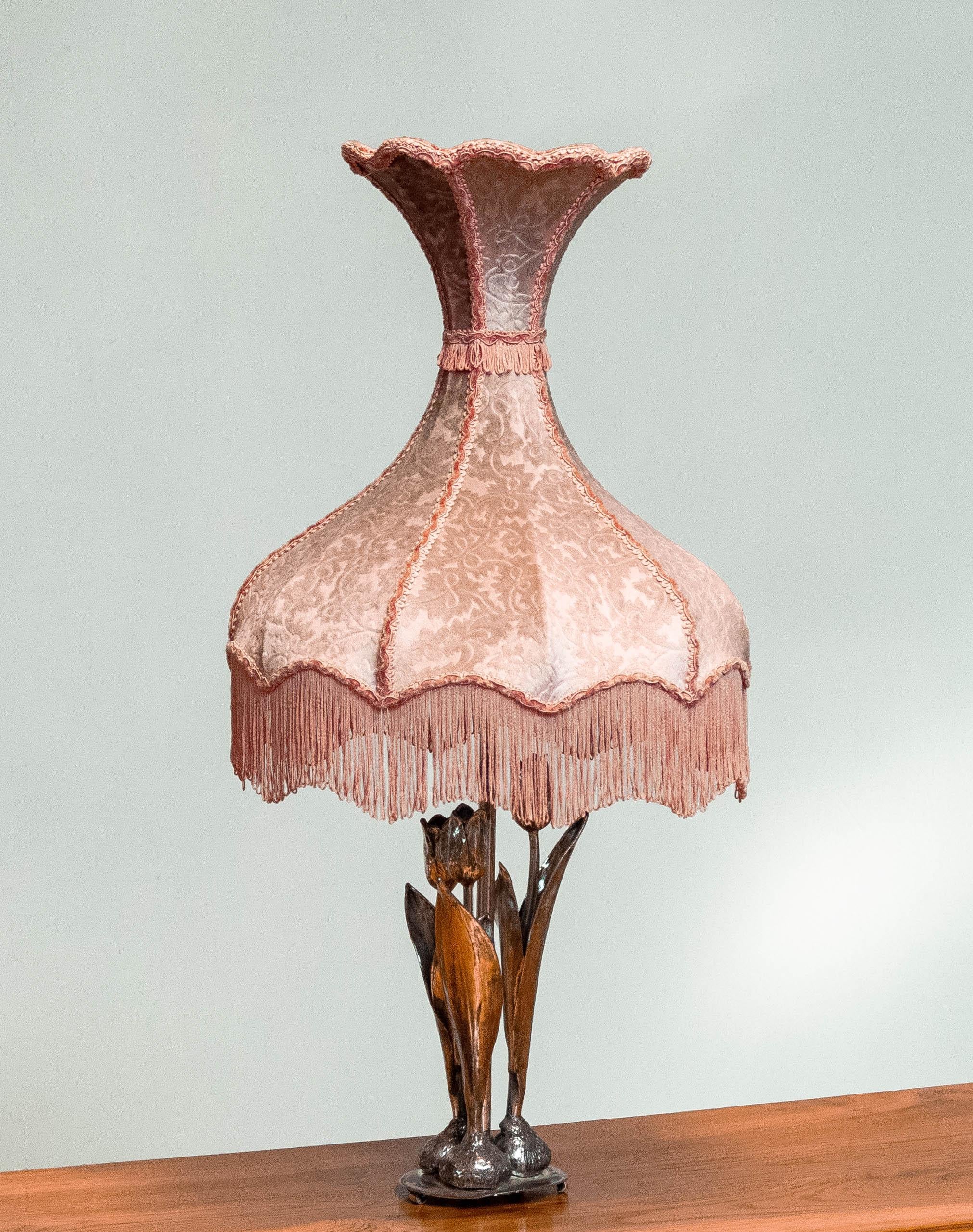 Absolument magnifique lampe de table argentée décorée de trois tulipes et d'un abat-jour de forme diabolo en velours rose vintage. ( Ausbrenner velvet )
Le support en argent a été fabriqué en 1965 en Suède et est signé H.Pegefors 1965. 
La lampe de