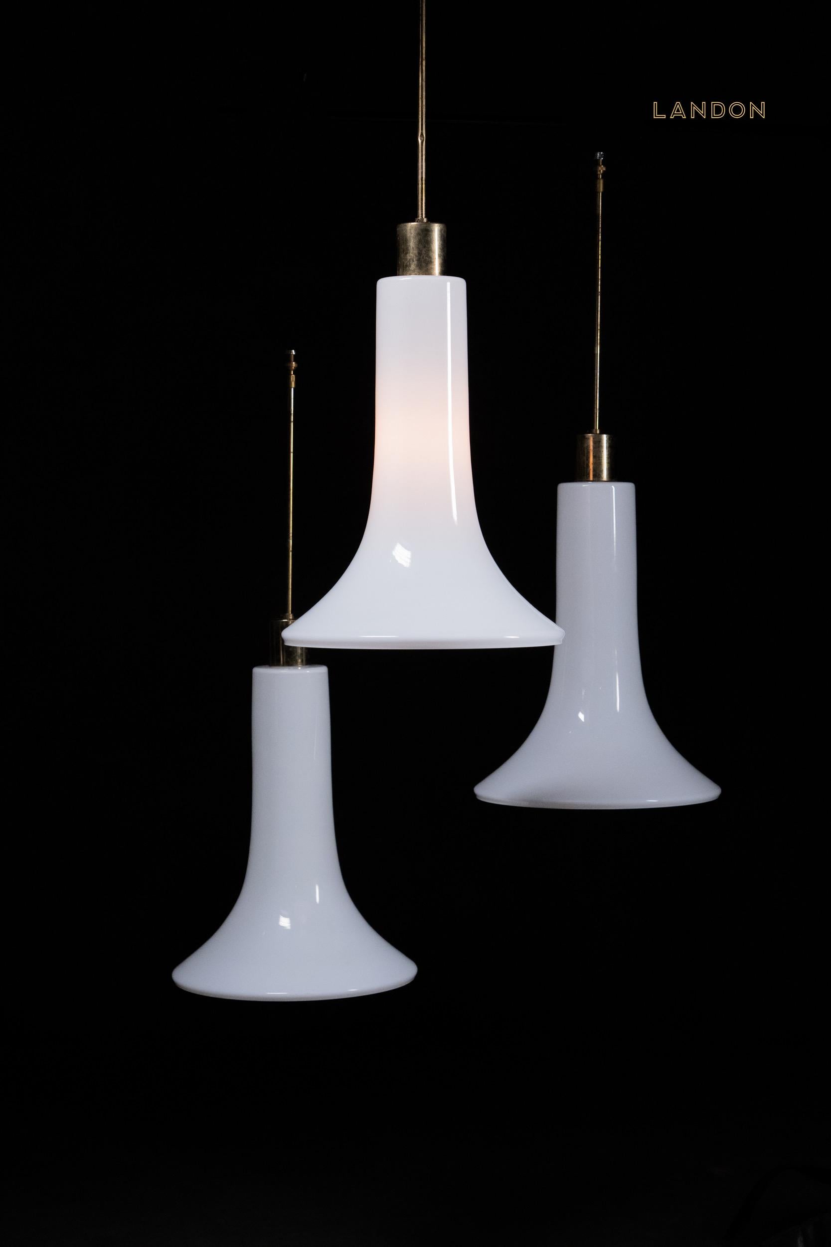 Un bel set di paralumi in vetro latte MCM a forma di cono su tubature in rame recuperate da un bistrot francese. Le luci sono d'epoca con alcuni difetti sul tubo di ottone originale. 

È anche possibile, in base alla discussione, che questi