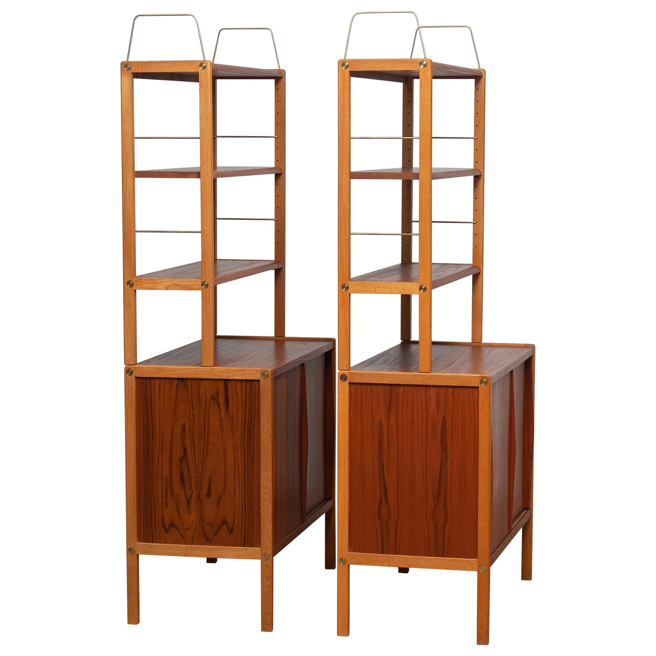 Beautiful and elegant set of two teak bookcases or cabinets with brass details and two sliding doors by Bertil Fridhagen for Bodafors, Sweden, 1960s.

Both lower parts of the cabinets have two sliding doors and inside the original shelves with