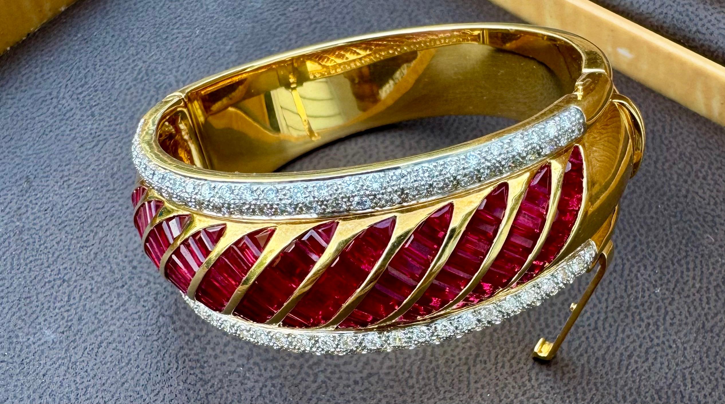 Wir präsentieren einen atemberaubenden Armreif im Vintage-Stil aus dem Jahr 1960 mit einem unsichtbaren Satz natürlicher Burma-Rubine, ergänzt durch Diamanten im Brillantschliff. 
Die Armspange zeigt in 11 schrägen Reihen angeordnete Rubine in