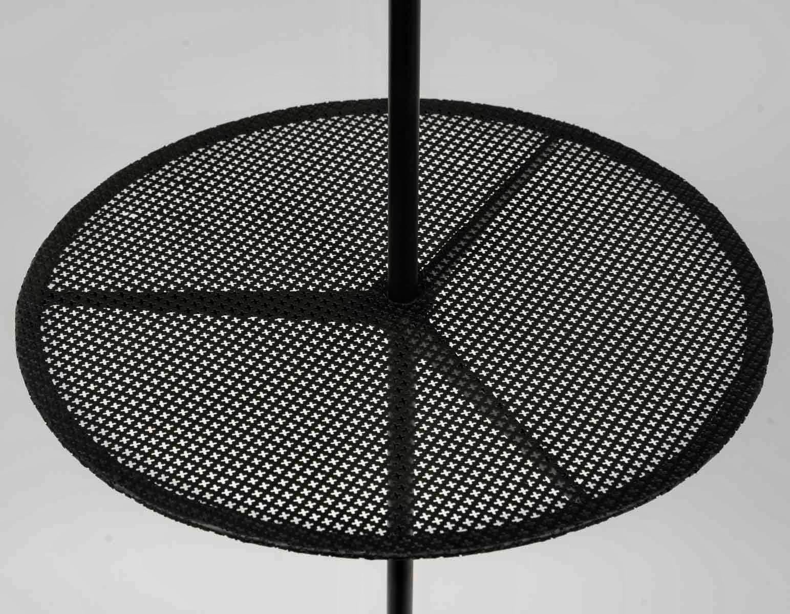 È composta da uno stelo centrale che poggia elegantemente su un treppiede rotondo in ferro battuto nero.
A metà altezza del fusto centrale si trova una mensola circolare in ferro perforato che funge da piedistallo.
In cima allo stelo centrale, un