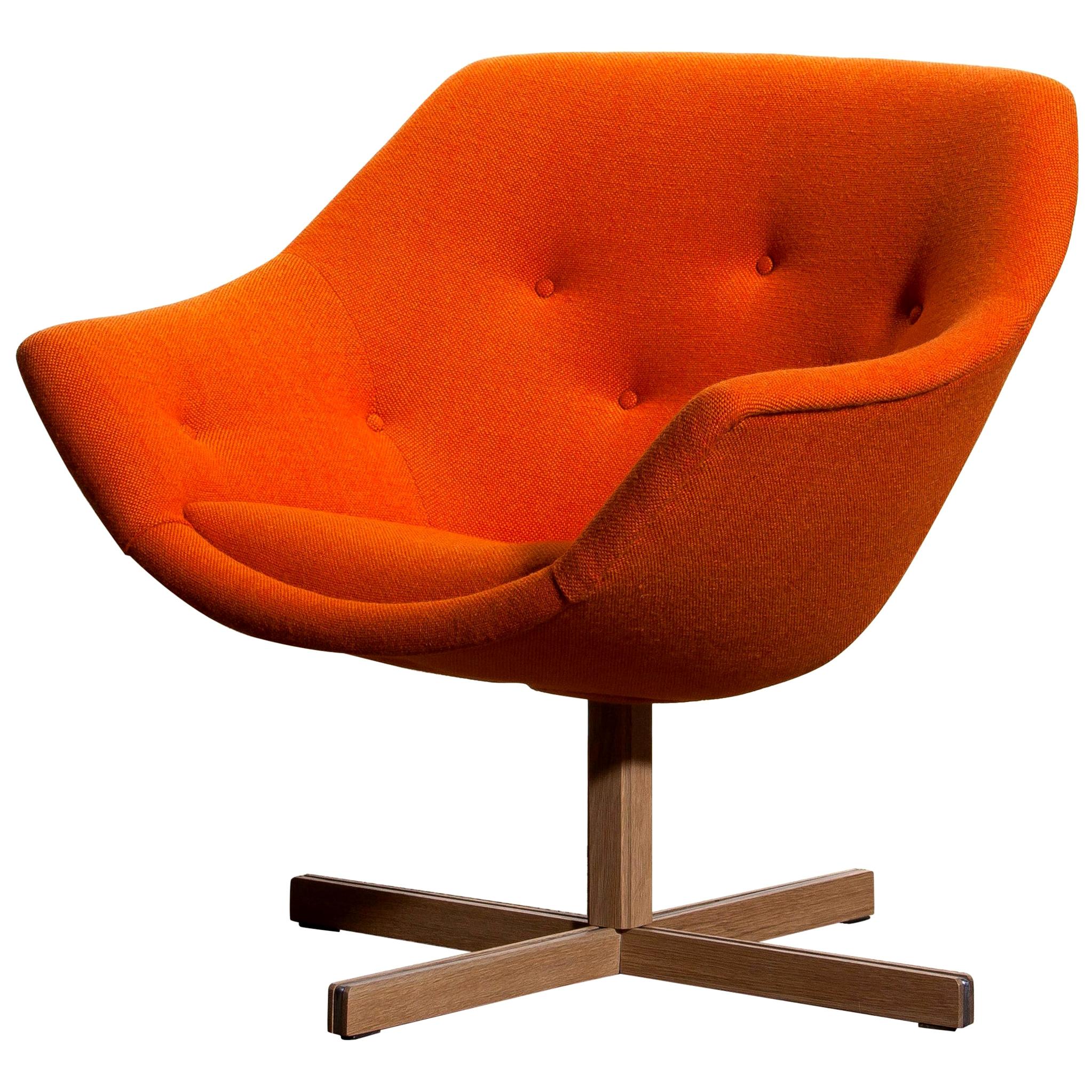 Fantastic 'Mandarini' swivel armchair made by Carl Gustaf Hiort for Puunveisto Oy, wood work Ltd. This chair is upholstered with a buttoned orange fabric 'Hallingdal' by Kvadrat designed by Nanna Ditzel on an oak swivel base.
It is in perfect and