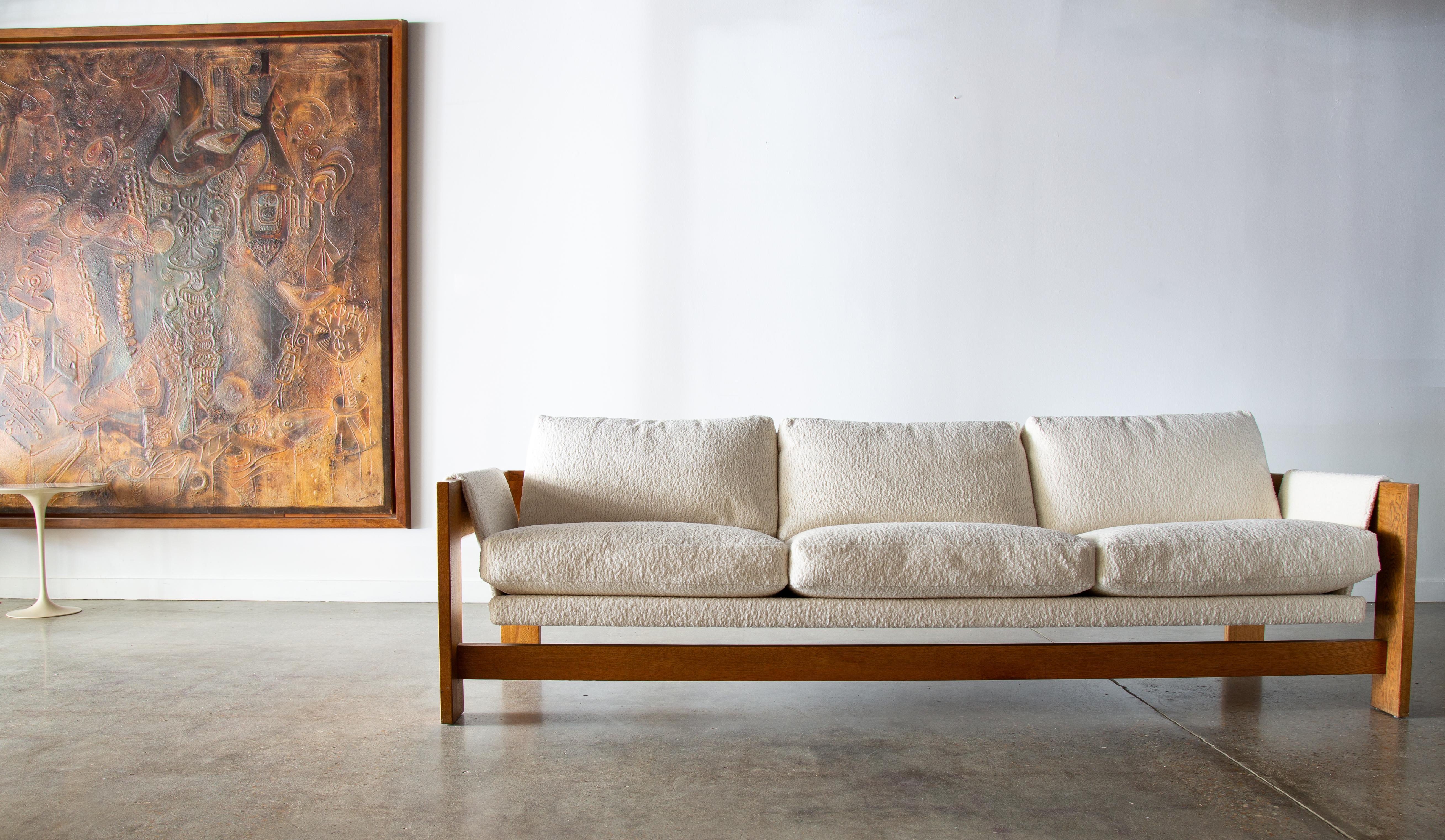 A very unique design by Jules Heumann for Metropolitan Furniture of San Francisco Ca. This 1960s sofa suspends from a solid oak frame and appears to float in suspension.  A unique hidden iron system ties the back bar to the sofa and a sling ties it