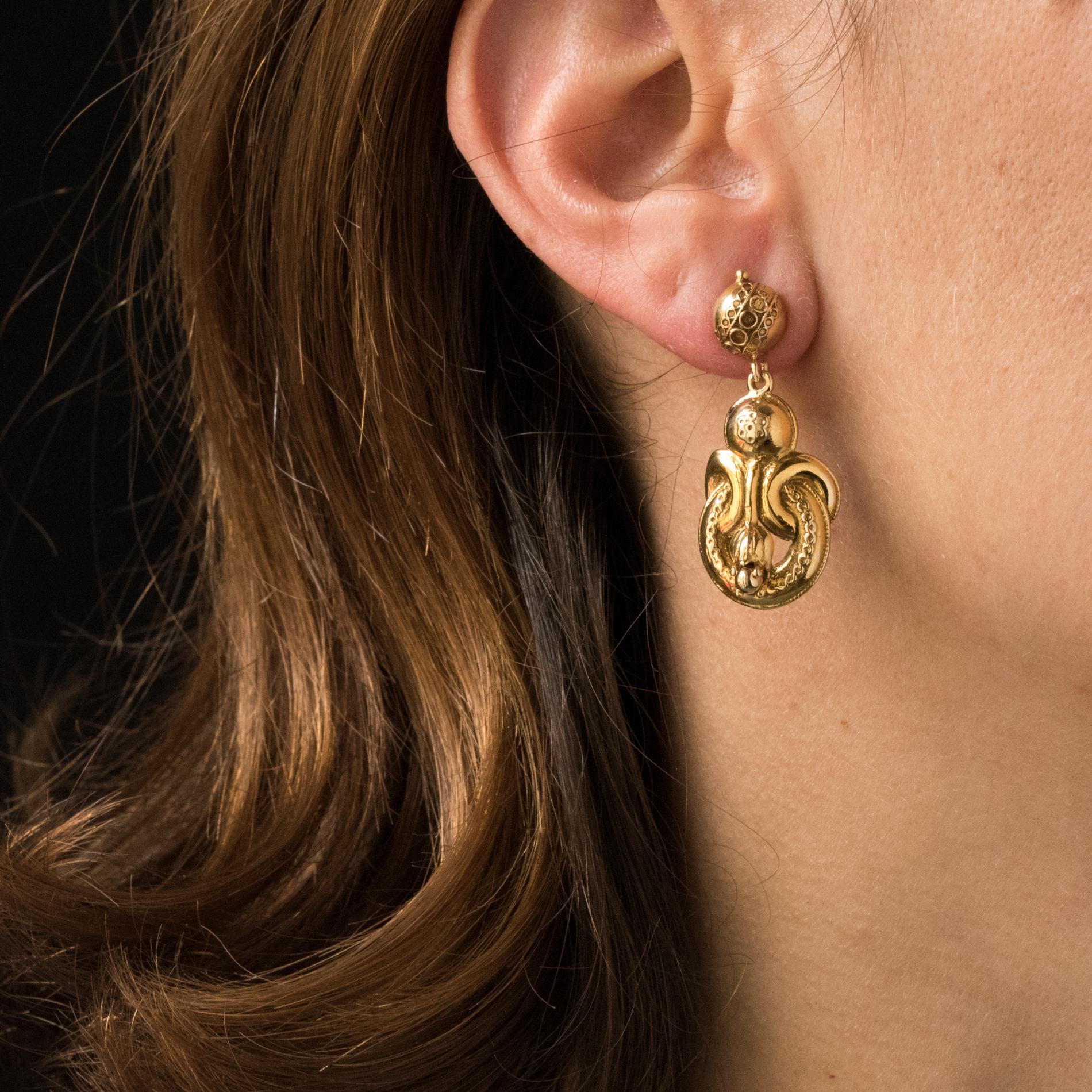 Earrings in 14 karats yellow gold.
Dangle earrings, they are composed of a half pearl of gold, chiselled, which retains in pendent a chiselled pattern adorned with vegetal and floral decoration. The clasp is a butterfly.
Length: 3.5 cm, width: 1.5