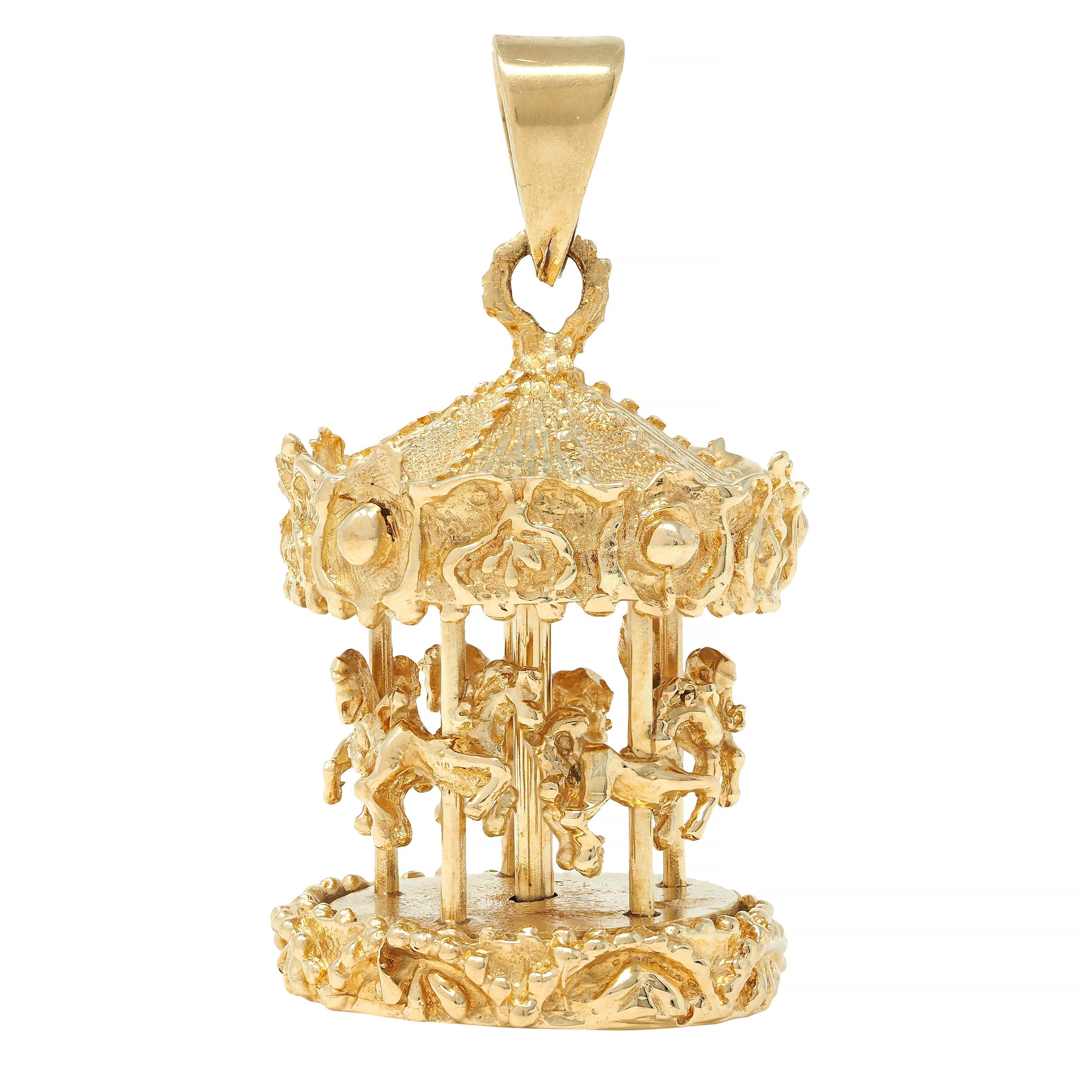 Designed as a carnival style carousel with five horses
Decorated with grooved and granulated tent and base
Horses spin around in circle via central axis
Suspending from tapered bale
Stamped for 14 karat gold
Circa: 1960s
Measures: 7/8 x 1 1/2 inches