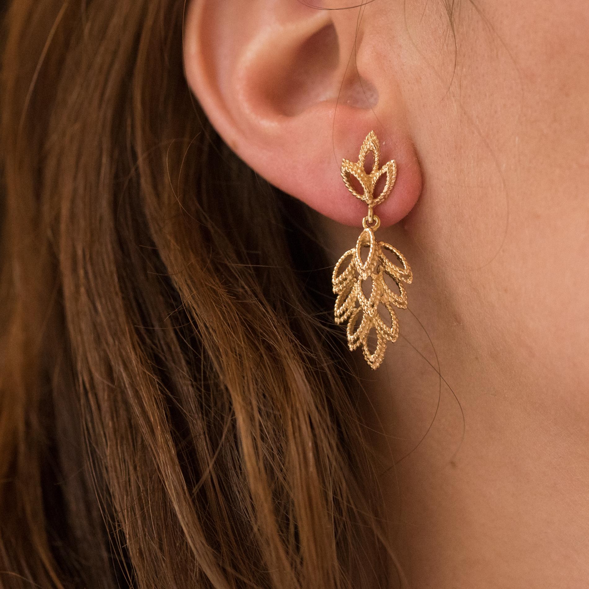 Earrings in 14 karats yellow gold.
Splendid dangle earrings, they are made of 3 perforated patterns in shuttle shape each made by 2 cords of gold. These motifs hold in pendent a pendant consisting of the same pattern all assembled as a leaf. The