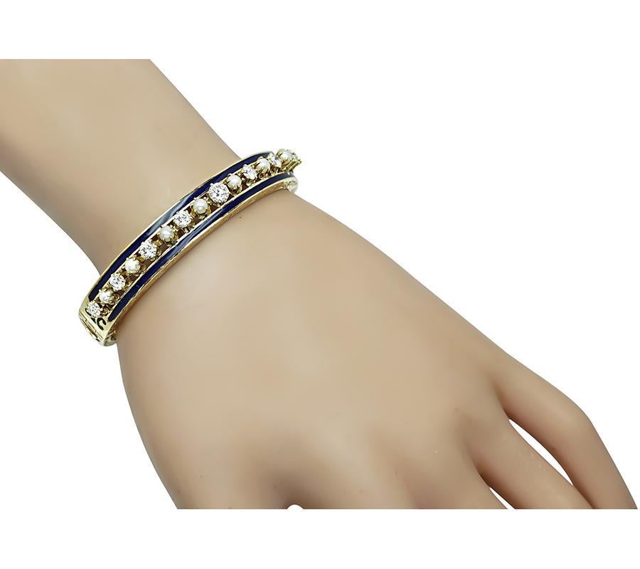 This is a charming 14k yellow gold bangle from the 1960s. The bangle is set with sparkling round cut diamonds that weigh approximately 1.40ct. The color of these diamonds is H with VS2 clarity. The diamonds are accentuated by lovely pearl and enamel